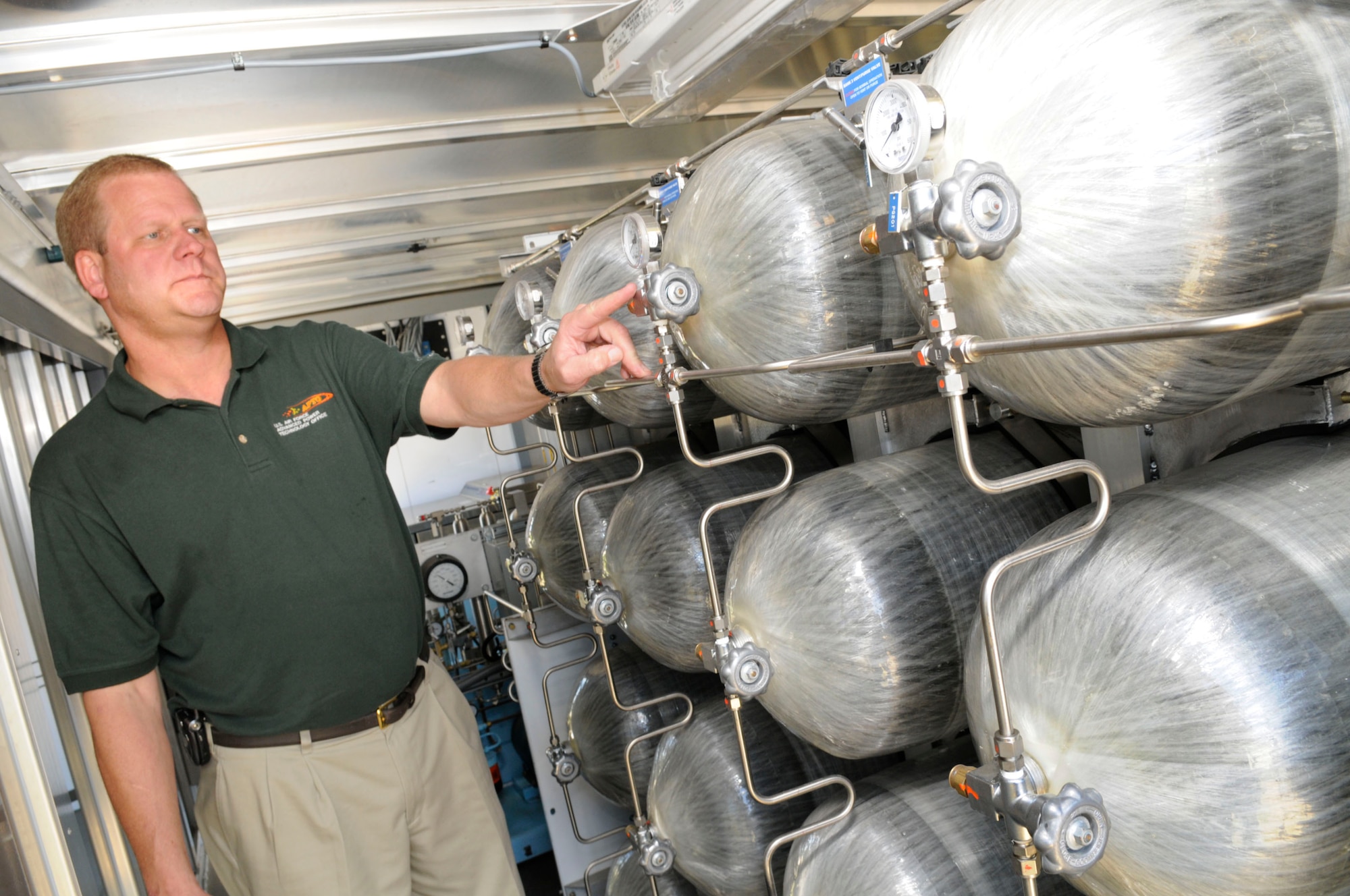 Scott Slyfield, Advanced Power Technology Office program manager, shows off the hydrogen storage tanks inside the HyHauler. U.S. Air Force photo by Sue Sapp
