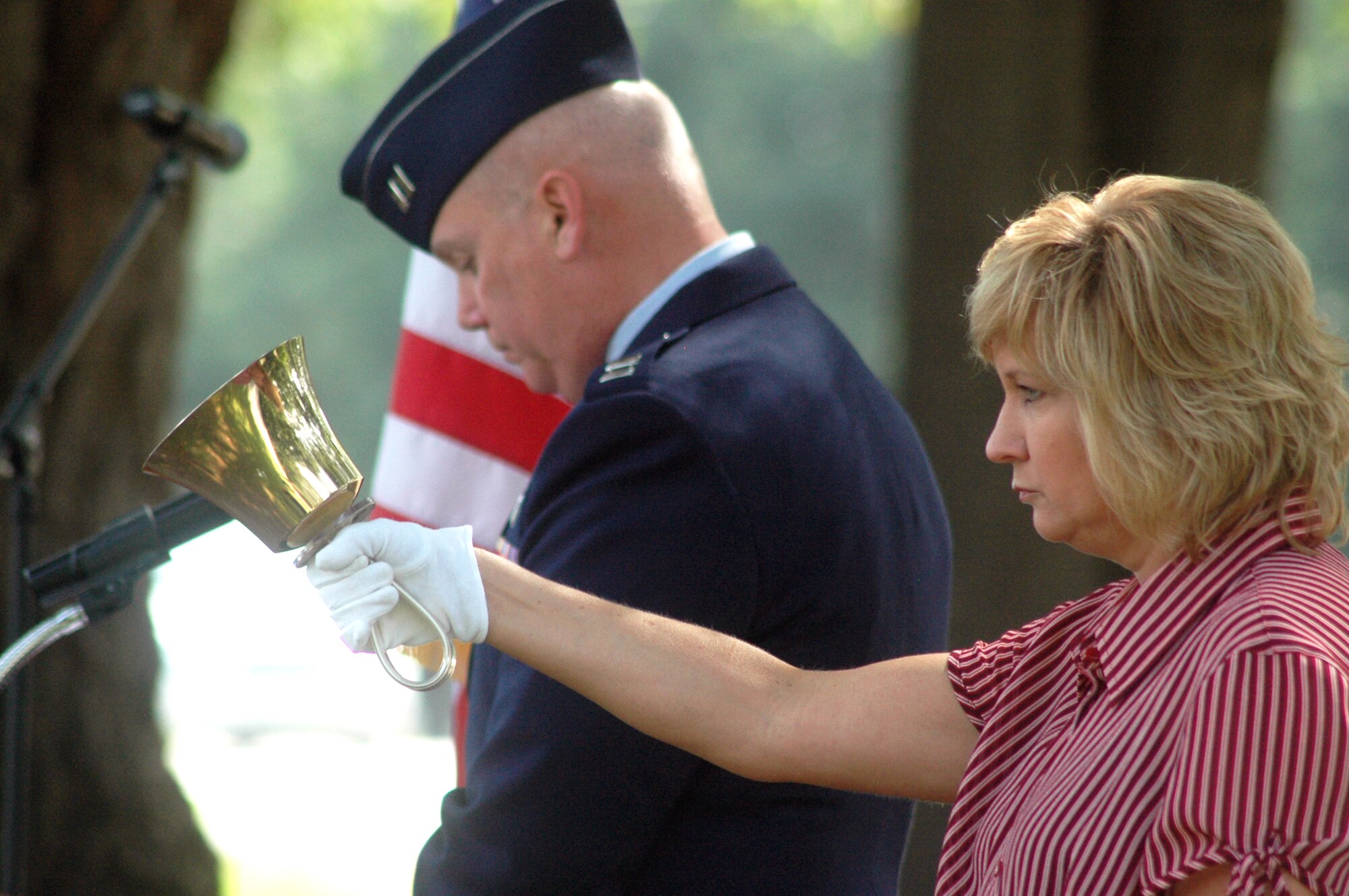 Chaplain (Capt) Paul Joyner reads the names of the honorees as Ms. Margaret Scheer tolls a bell for each one. U. S. Air Force photo by Sue Sapp