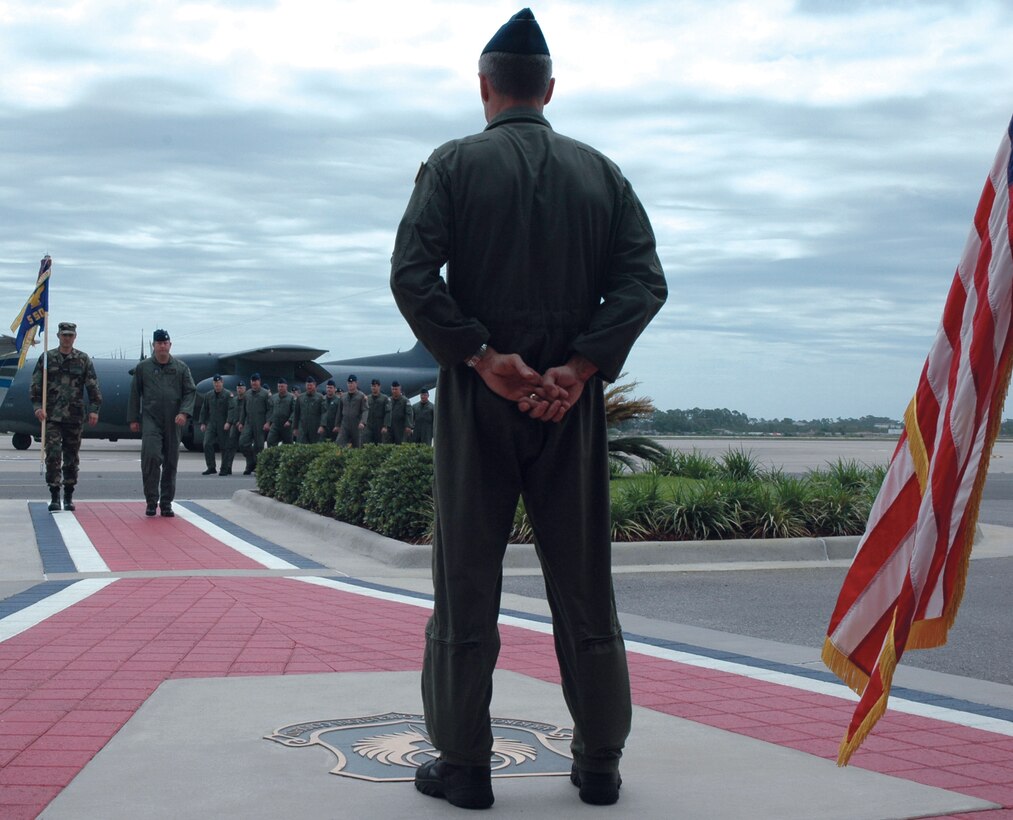 Col. Steven Chapman, 919th Special Operations Wing commander, prepares for Master Sgt. Daniel Dombrowski  (back left), 5th Special Operations Squadron first sergeant, and Lt. Col. Reid Henley (back right), 5th SOS commander, to present their squadron flag during a squadron transition ceremony at Hurlburt Field May 23. The ceremony marked the squadron's mission change from flying the MC-130P Combat Shadow at Eglin Air Force Base to operating the new Air Force Special Operations Training Center at Hurlburt Field. This event also marked their final flight on the MC-130P airframe. The squadron's new mission will revolve around the augmentation of training units for the U-28, the AC-130U Gun-ship and aviation foreign internal defense. (U.S. Air Force Photo/Jasmine DeNamur)