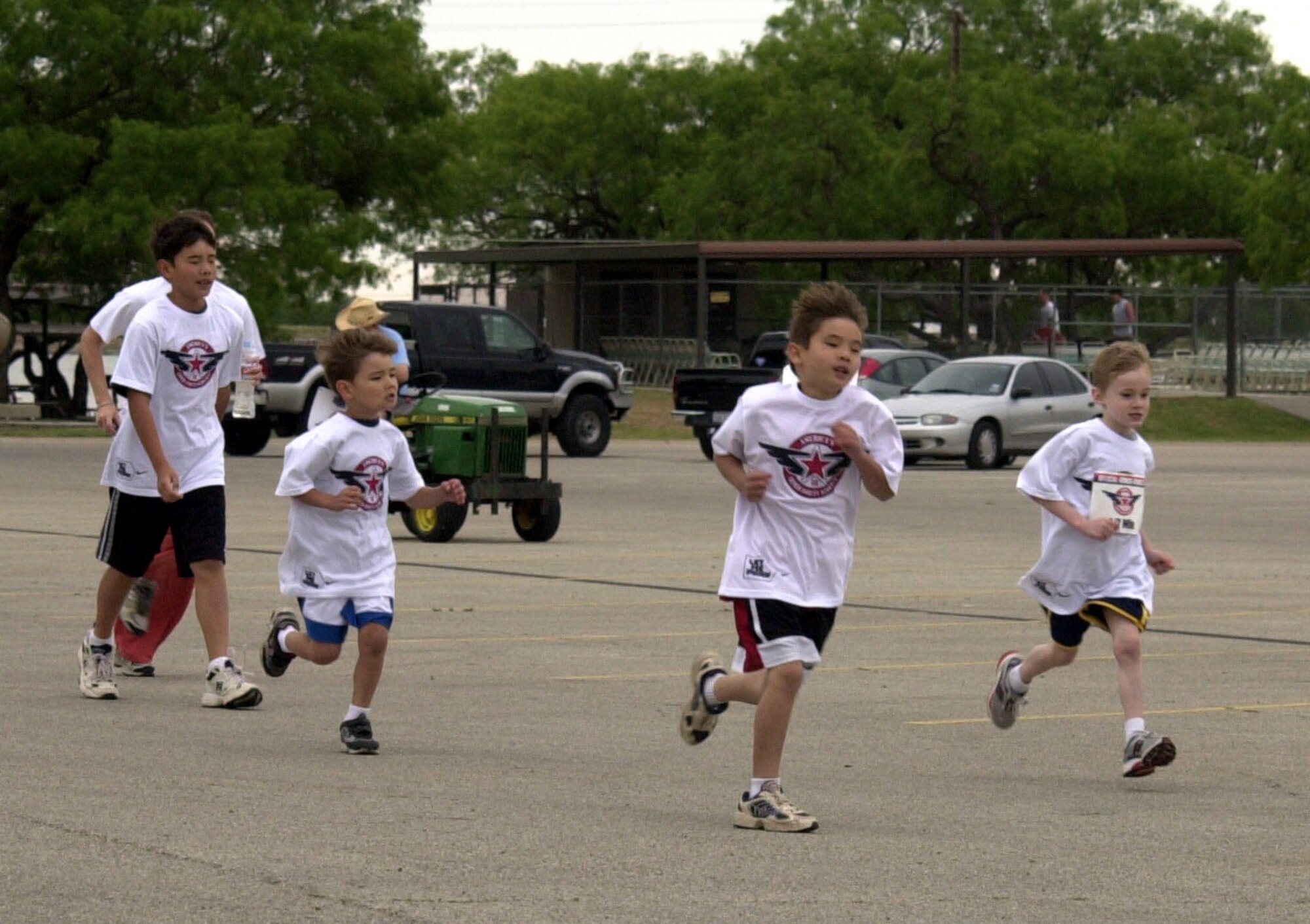 Runners in the Armed Forces Youth Relay race toward the finish at the Goodfellow Recreation Camp at Lake Nasworthy May 17. The relay, put on by the 17th?Services Division, took place at the same time as the Armed Forces Youth Fishing Derby. (U.S. Air Force photo by Senior Airman Stephen Musal)