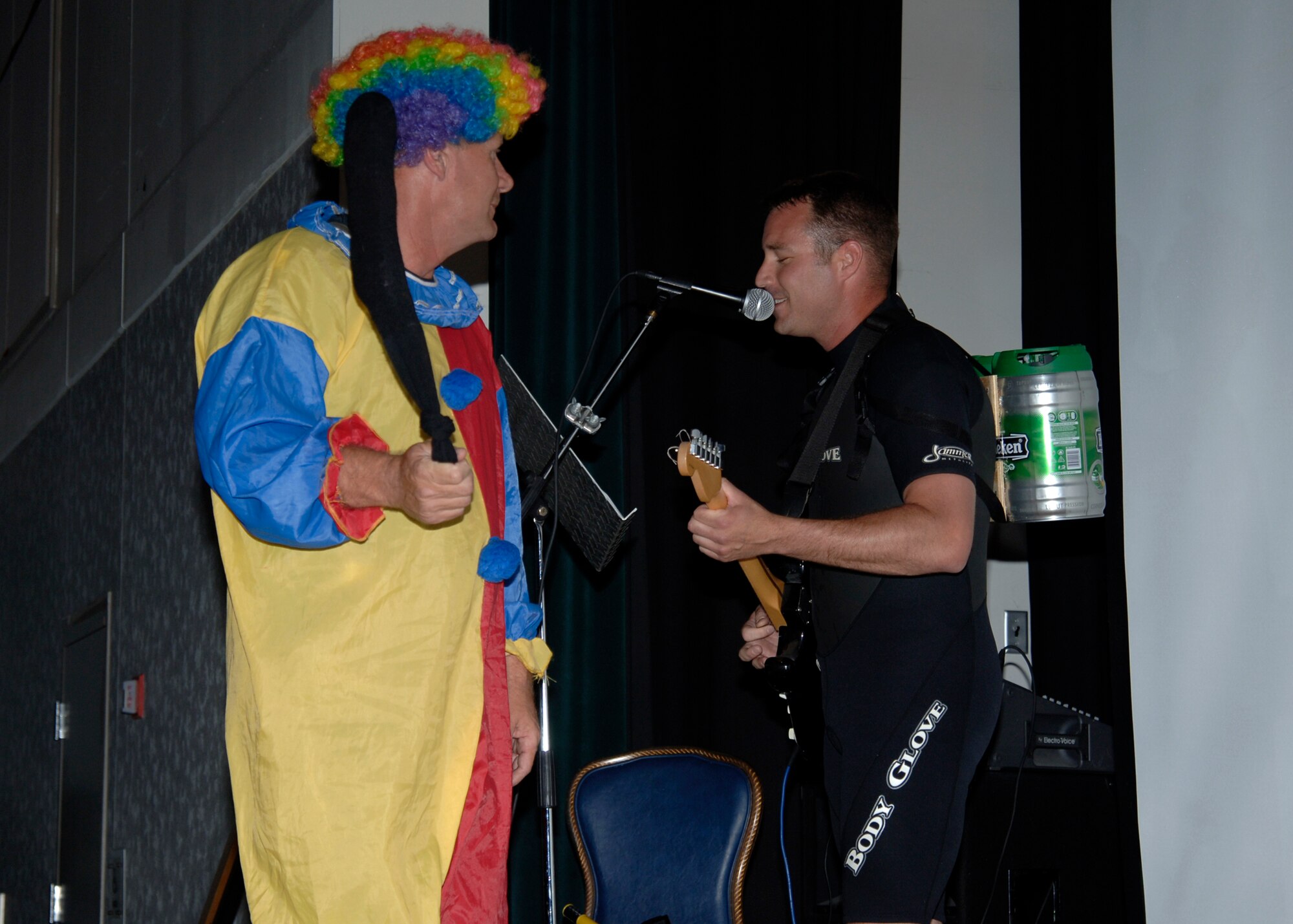 MCCONNELL AIR FORCE BASE, Kan. -- Master Sgt. Jason Nystrom, 22nd Mission Support Squadron first sergeant, donned in scuba gear, plays guitar, while Chief Master Sgt. John Gebhardt, 22nd Medical Group, clown, winds up a sock flogger during a wing Joust tournament, May 22, at the Robert J Dole Center ballroom. Sergeant Nystrom taunted Chief Gebhardt with his lyrics before they jousted. (Photo by Airman Justin Shelton)