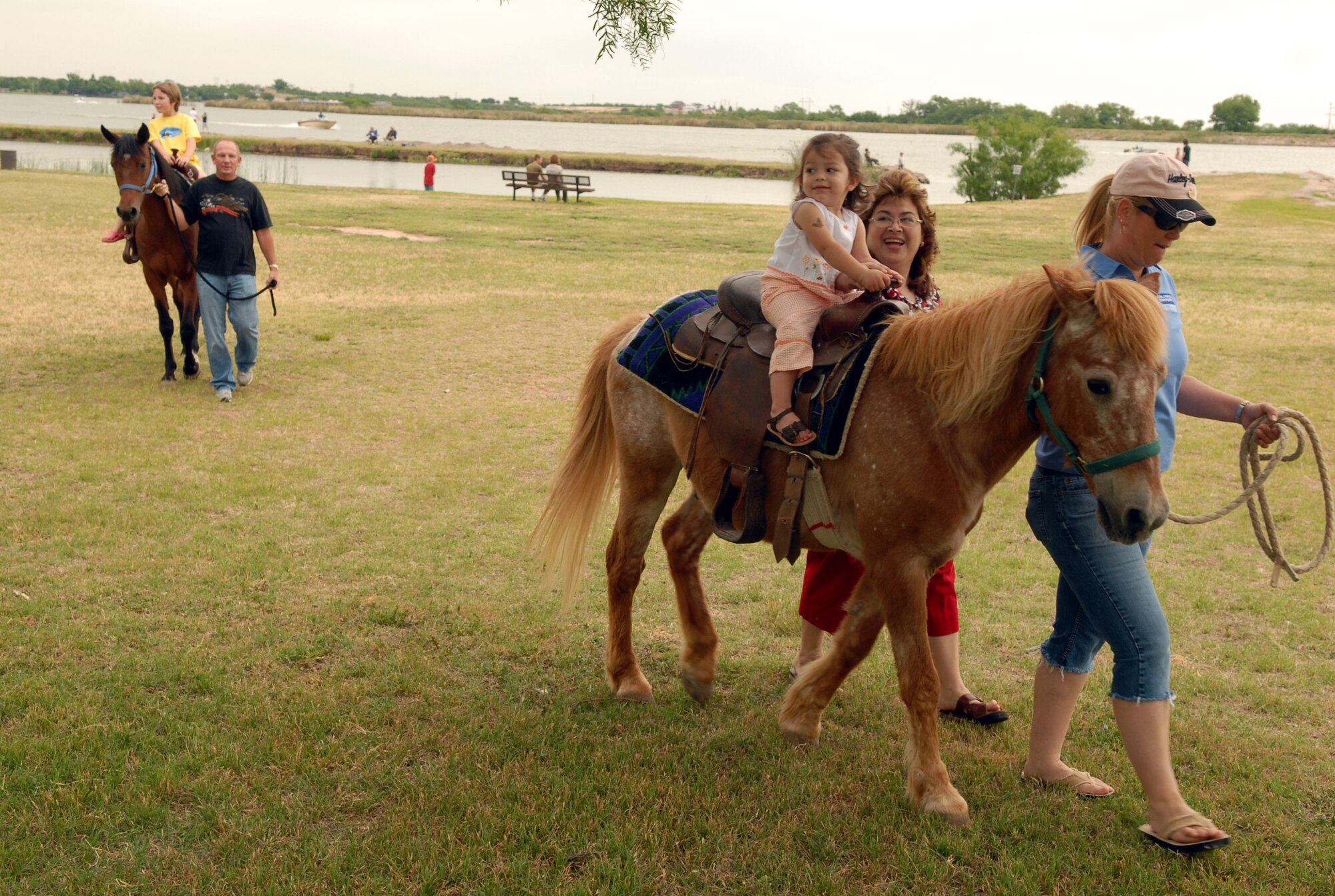 Some of the younger attendees at the third annual Goodfellow Appreciation Picnic try their hands at riding ponies while their parents look on May 17. (U.S. Air Force photo by Staff Sgt. John Barton)