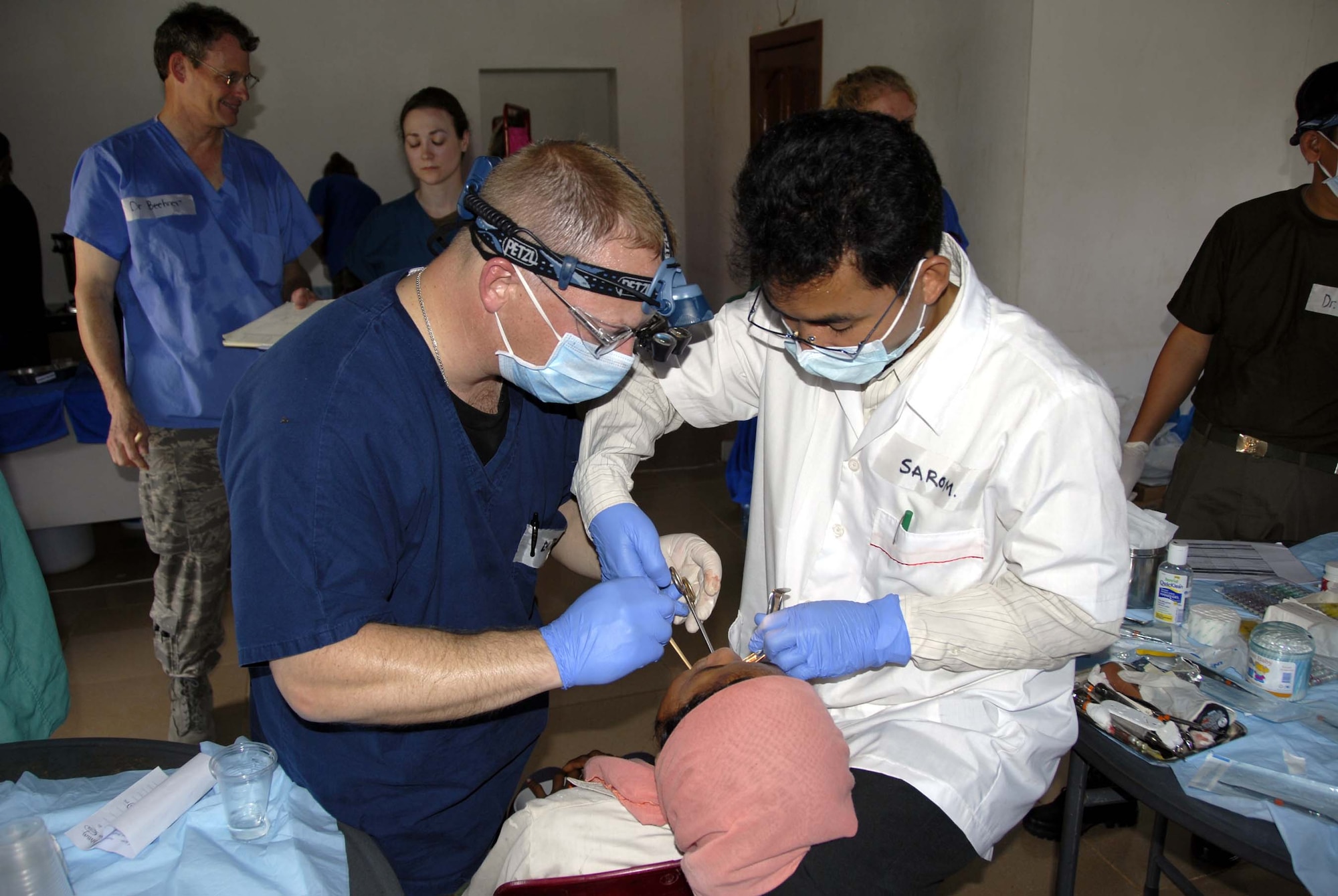 KAMPONG CHHNANG PROVINCE, Cambodia -- Major Philip Clark, (left) a Dentist 194th Medical Group, Washington State Air National Guard and Sar Sarom (right) a Cambodian dental student perform surgical tooth extraction on a Cambodian woman here at the provincial Friendship clinic May 25. A 13th Air Force led total force team of Active Duty, Reserve and National Guard members are working with doctors from the Royal Cambodian Armed Forces, Cambodian dental students and other non-governmental organizations during Pacific Angel 08 May 25 – 29 to provide cost free medical care to the people of Cambodia at three different operating locations. Operation Pacific Angel is a joint/combined multi-national humanitarian assistance operation conducted in the Pacific area of responsibility in support USCDRPACOM capacity-building efforts.  Participating services include the Active, Reserve and National Guard components of the U.S. Air Force, U.S. Army, Royal Thai Air Force (RTAF), and Royal Cambodian Armed Forces (RCAF). (U.S. Air Force photo/Tech. Sgt. Tom Czerwinski)

