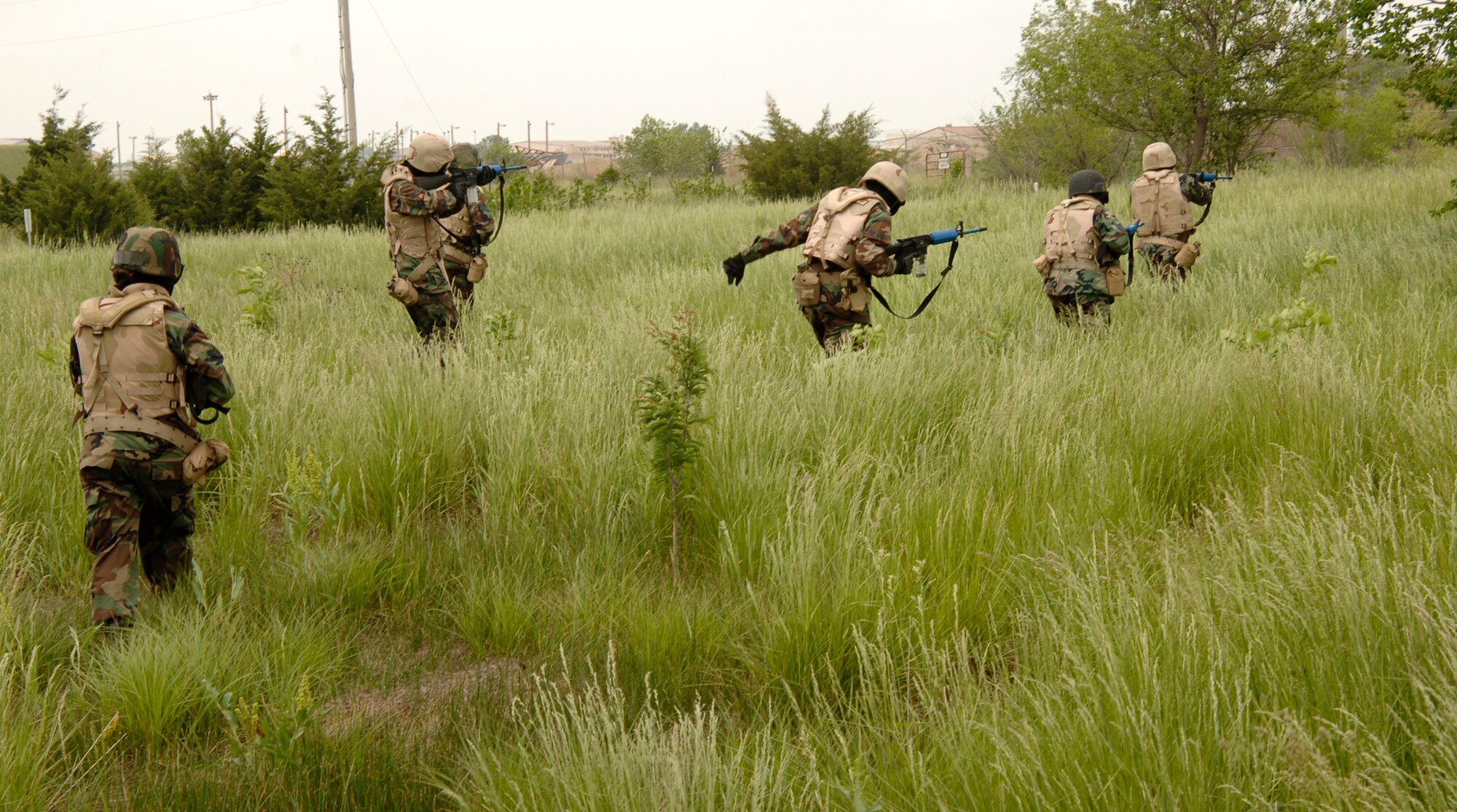 MCCONNELL AIR FORCE BASE, Kan. -- Combat skills training members march through a field towards a mock hostile village at the base obstacle course, May 22. The team was composed of six members from fire teams bravo and delta and was tasked with securing the village and all four of the buildings. (Photo by Airman Justin Shelton)