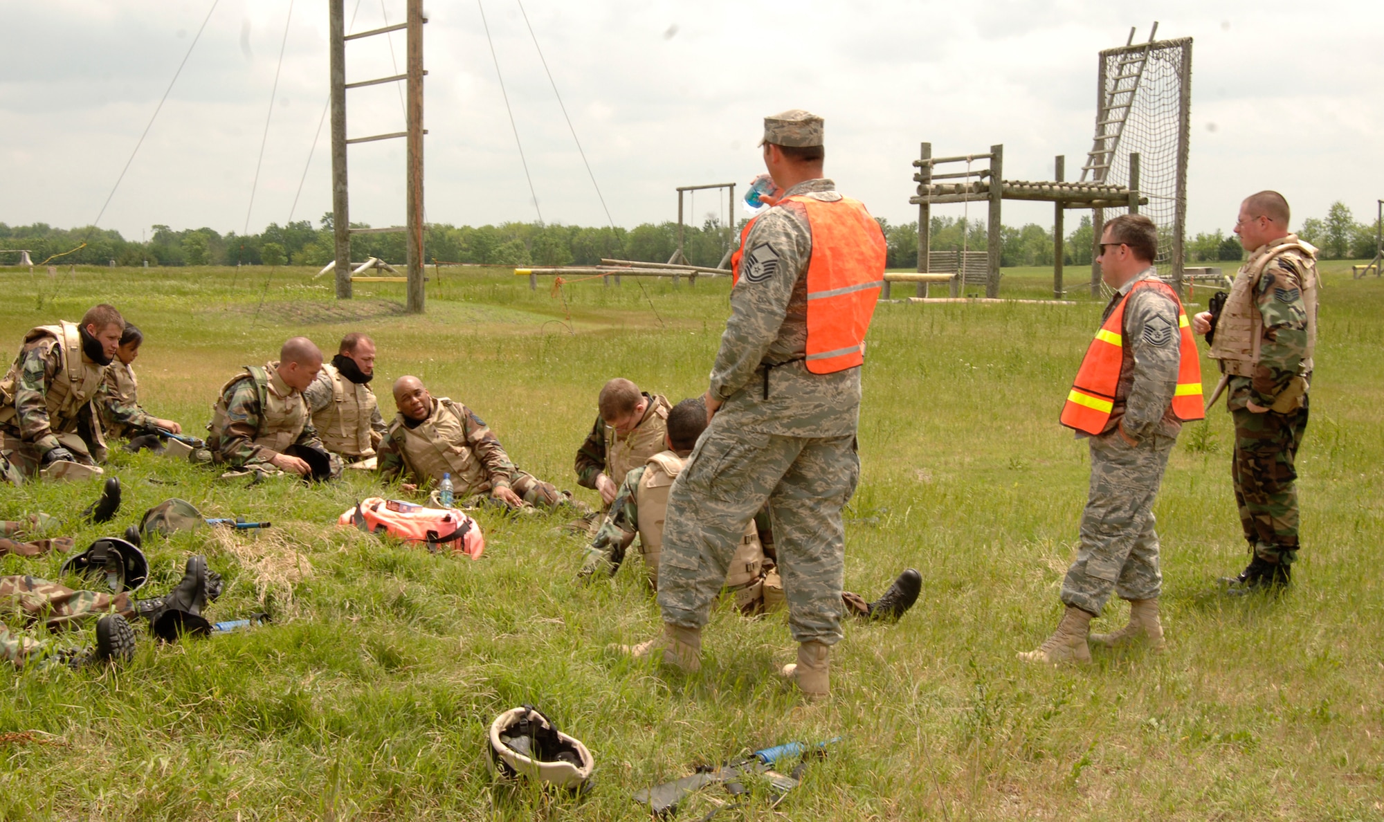 MCCONNELL AIR FORCE BASE, Kan. -- Masters Sgt. Gregory Cohen and Peter Nusspickel, 22nd Security Forces Squadron, give the combat skills trainees a chance to hydrate before resuming their efforts to take over a mock hostile village at the base obstacle course, May 22. Safety was a priority throughout the training. Students had protective face masks and gloves in addition to their regular personal protective equipment. (Photo by Airman Justin Shelton)