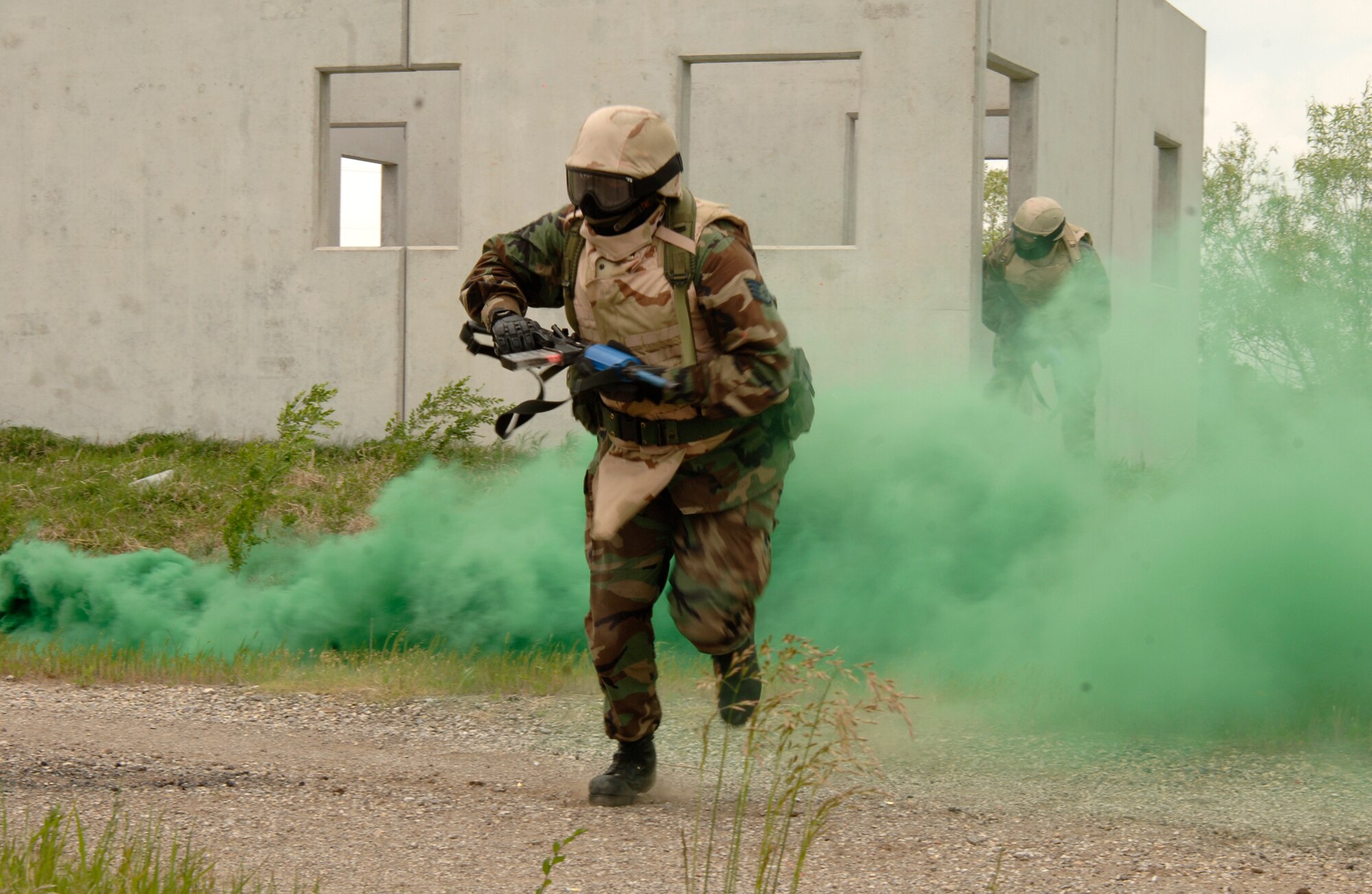 MCCONNELL AIR FORCE BASE, Kan. -- Staff Sgt. Scott Wilburn, 22nd Maintenance Squadron, runs through a cloud of smoke while clearing a mock village during combat skills training at the base obstacle course, May 22. Sergeant Wilburn was a member of Fire Team Alpha and was running to assist his team in clearing the next building. (Photo by Airman Justin Shelton)