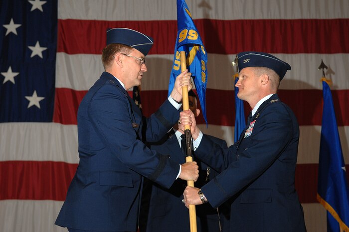 NELLIS AIR FORCE BASE, Nev.—Brig. Gen. Stephen L. Hoog, United States Air Force Warfare Center commander, passes the 99th Air Base Wing flag to Col. Howard D. Belote during a change of command ceremony at the Thunderbirds hangar here May 29, 2008. Colonel Belote assumes command of the 99th ABW after serving as the Combating Weapons of Mass Destruction Division chief on the Joint Staff at the Pentagon, Washington, D.C. (U.S. Air Force photo/Senior Airman Larry Reid Jr.)