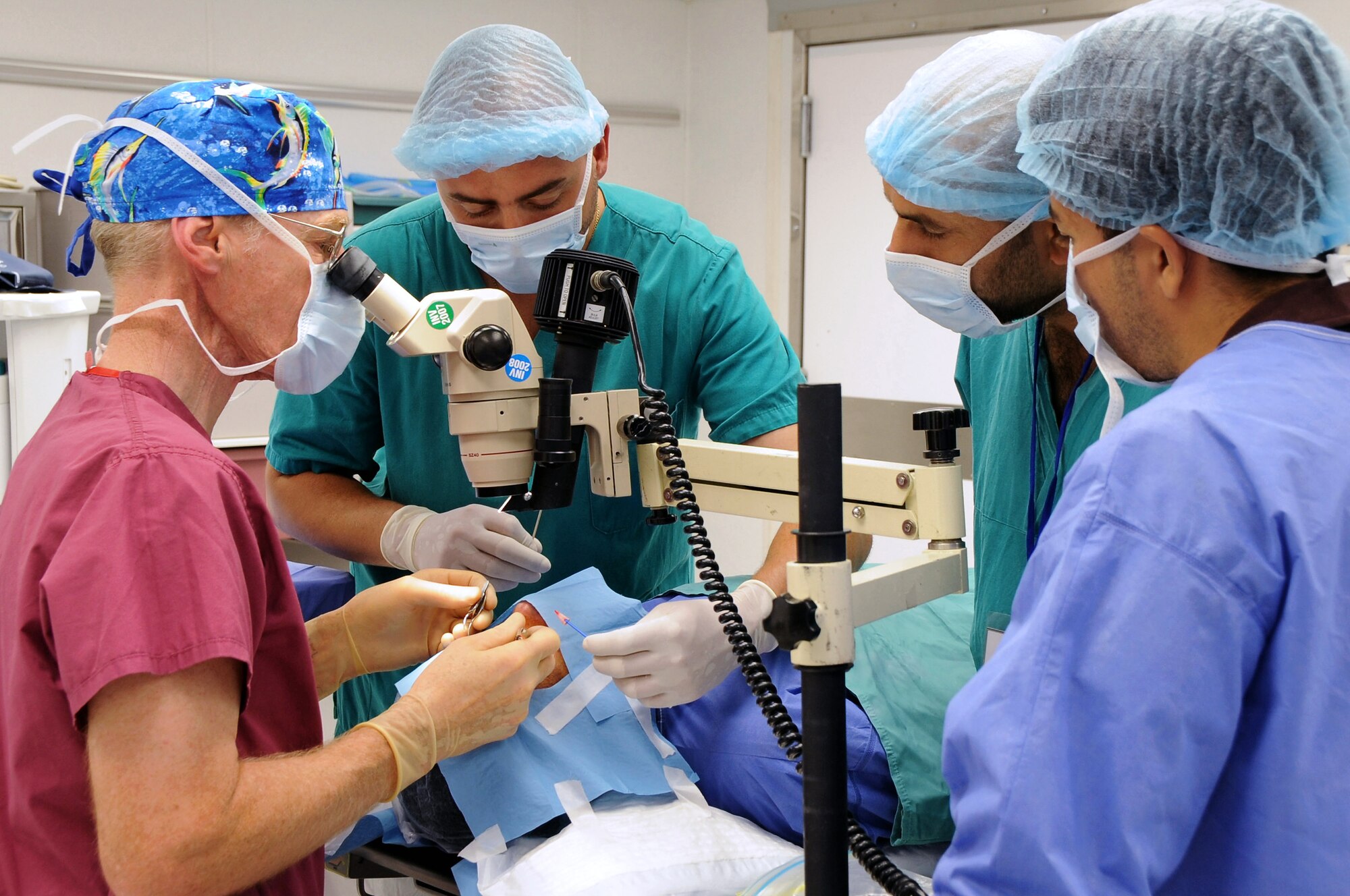 Retired Colonel Stephen Waller, a contract ophthalmologist from Wilford Hall Medical Center, Lackland Air Force Base, Texas, works with his medical team to perform an eye surgery here May 20. His team is comprised of two Iraqi doctor's assistants from the Nasiriyah General Hospital and two provincial reconstruction team members. The doctor came to Iraq to provide eye exams, surgeries and free glasses to hundreds of Iraqis in need. Doctor Waller arrived here May 18 and finished his humanitarian mission four days later. (U.S. Air Force photo/Tech. Sgt. Sabrina Johnson) 