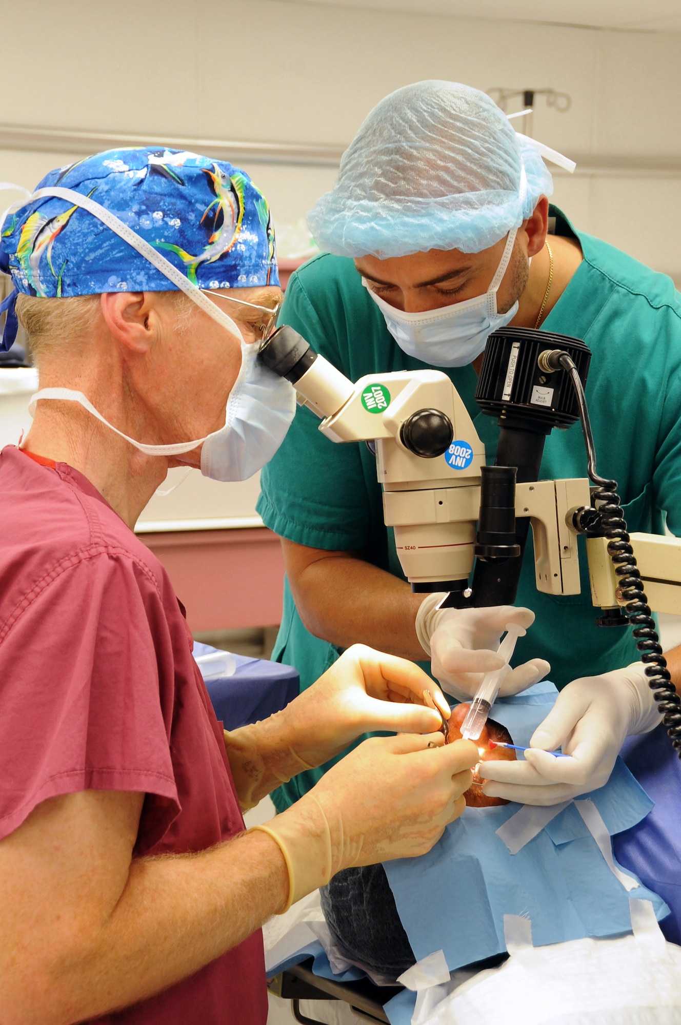 Retired Air Force Colonel Stephen Waller, a contract ophthalmologist from Wilford Hall Medical Center, Lackland Air Force Base, Texas, works with his medical team to perform an eye surgery here May 20. His team is comprised of two Iraqi doctor's assistants from the Nasiriyah General Hospital and two provincial reconstruction team members. The doctor came to Iraq to provide eye exams, surgeries and free glasses to hundreds of Iraqis in need. Doctor Waller arrived here May 18 and finished his humanitarian mission four days later. (U.S. Air Force photo/Tech. Sgt. Sabrina Johnson) 