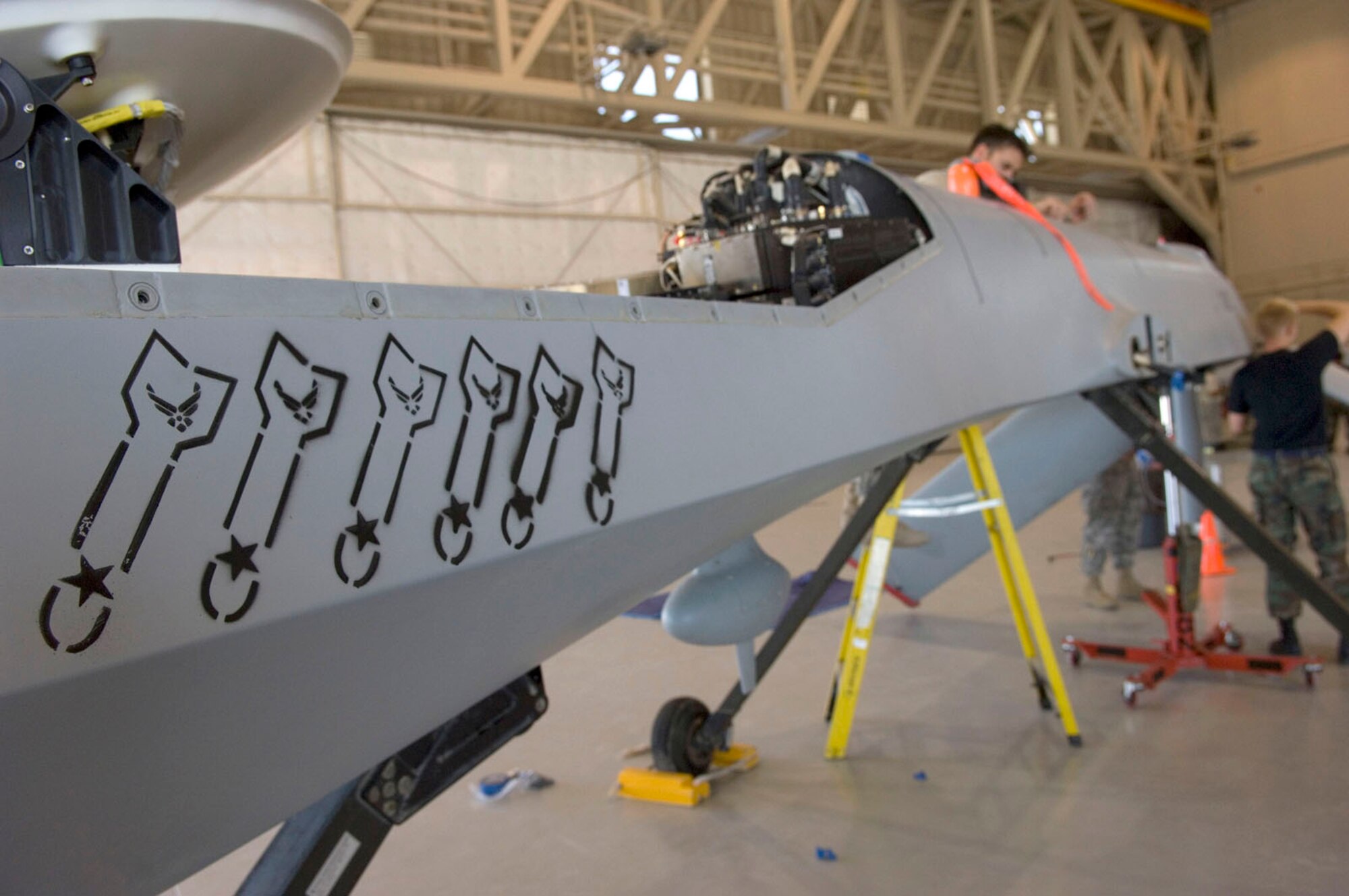 Airmen assigned to the 432nd Aircraft Maintenance Squadron, assemble a MQ-1 Predator after returning from Afghanistan here May 19, 2008. The six images on the side of the MQ-1 Predator symbolizes the number of hell fires shot while in combat.
(U.S. Air Force Photo by/Senior Airman Larry E. Reid Jr.)