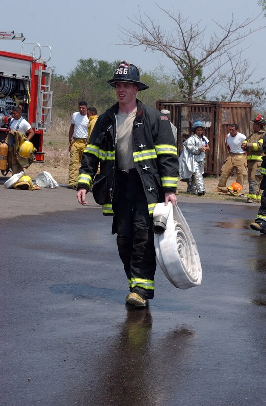 Sergeant Michael Foley, Crew Chief of 356 Engineer Detachment Fire fighters out of Danvers, Massachusetts carries a fire hose to attach to a truck during a training exercise held with the local fire department on on Soto Cano Air Force Base, Honduras on May 01, 2008 during the training exercise Beyond the Horizons 2008.  Beyond the Horizons is a joint forces training exercise  between the United States and Honduras to foster goodwill and improve relations between the two nations. (Photo by SGT Kathy Jo Young)(Released)