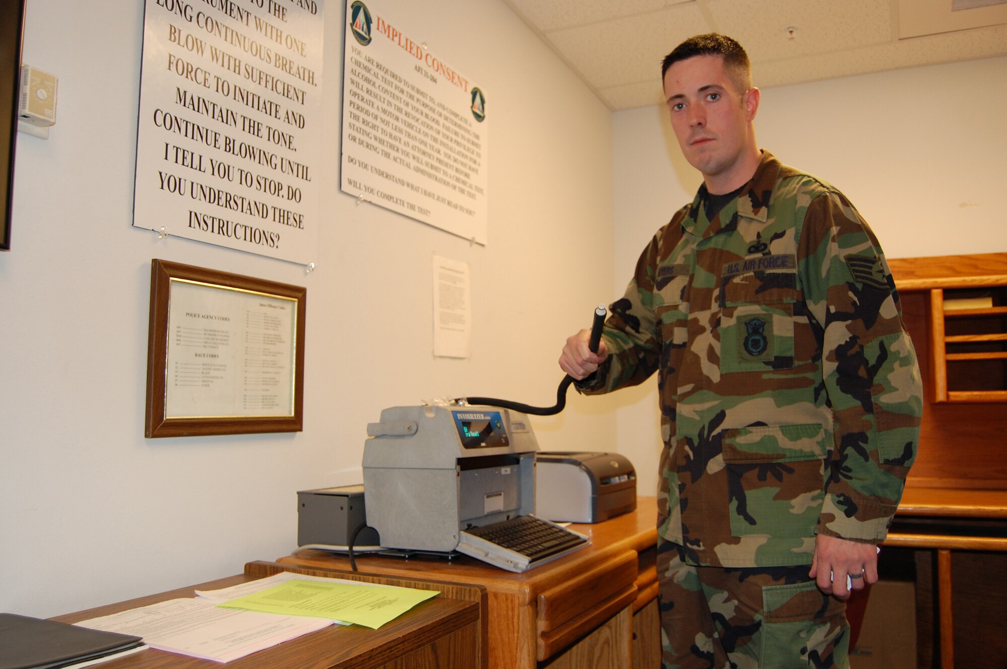 Staff Sgt. Jason Myers, 341st Security Forces Squadron NCO in charge of training, holds the breathing tube of the Intoxilyzer 8000. Sergeant Myers was recognized for his role in getting more law enforcement officials certified on the use of this instrument during a recent field sobriety test training session, among other accomplishments.(U.S. Air Force photo/Airman 1st Class Dillon White)