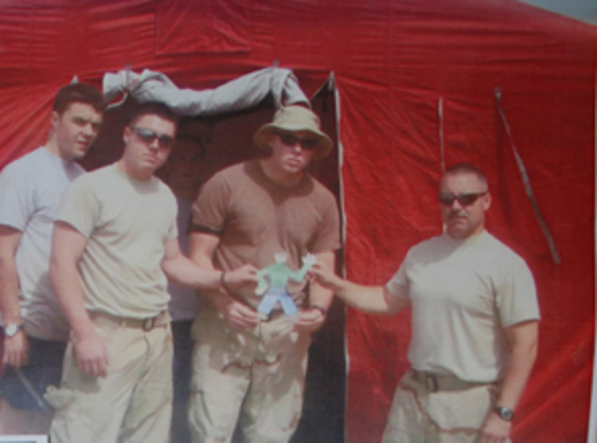 107th AW firefighters pose for a photo with "Flat Stanely" in Iraq.  This is one of many photos sent back to a second grade class that the firefighters corresponded with through their deployment.  From left to right:  Senior Airman Jason Berg, Senior Airman John Baylor, Senior Airman Richard Wesser, and Master Sgt. Dave Wall.