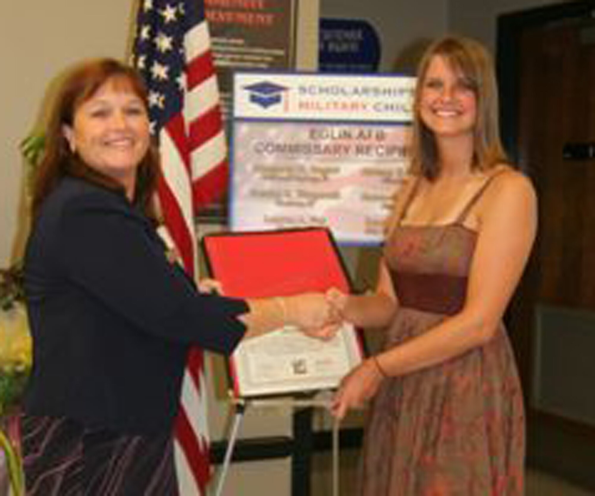 Commissary manager Luana Harris congratulates Rhapsody Bogart for being a recipient of a $1,500 scholarship in the Scholarships for Military Children Program.
