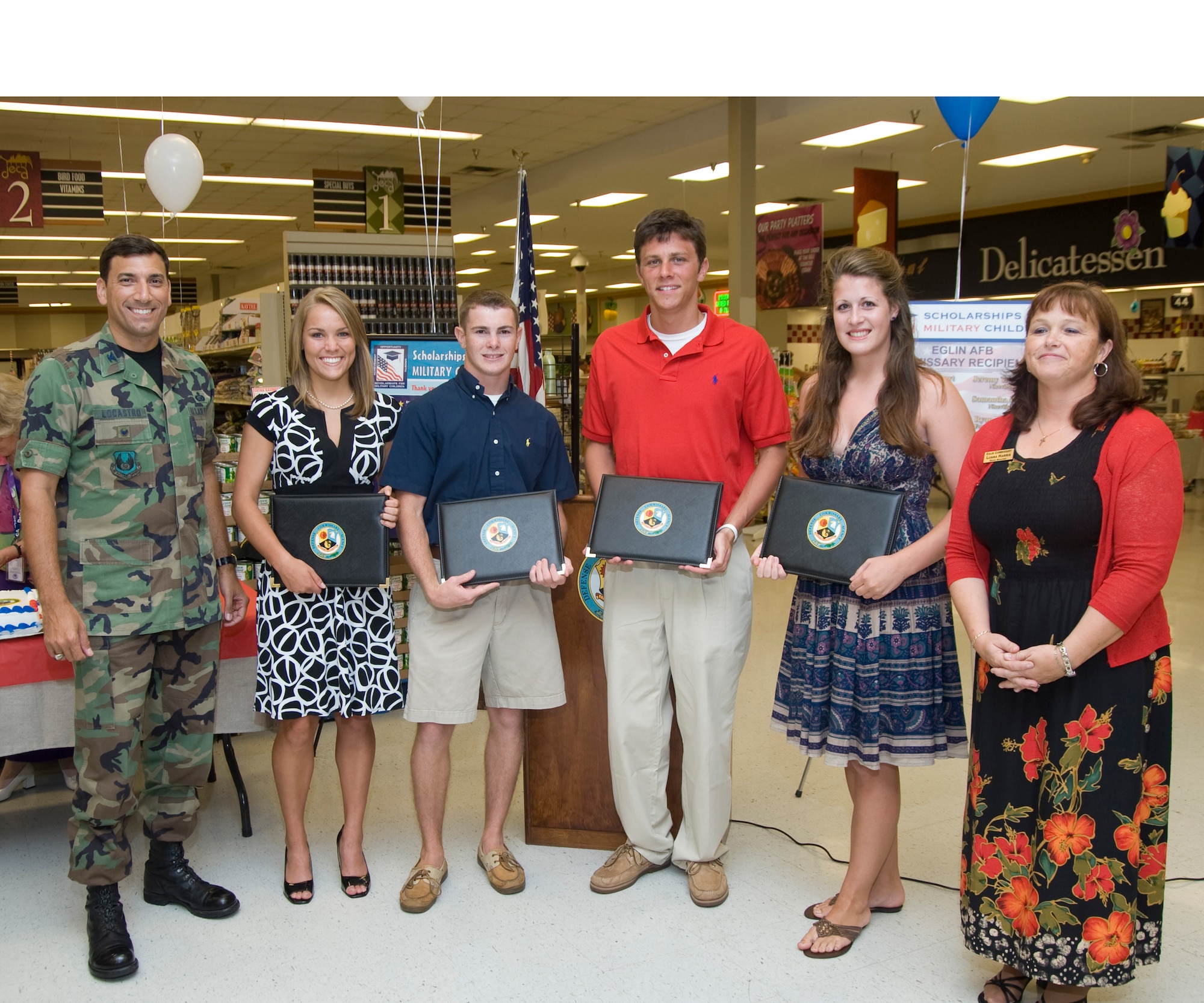 Col. Rick LoCastro, 96th Air Base Wing vice commander, and commissary manager Luana Harris presented scholarships to the following individuals as part of the Defense Commissary Agency's Scholarships for Military Children Program. The recipients are:  Lauren Foy, Patrick Fitzgerald, Ryan Urenda, Samantha Reho and Rhaposdy Bogart. (USAF photo by Wendell Rowan)