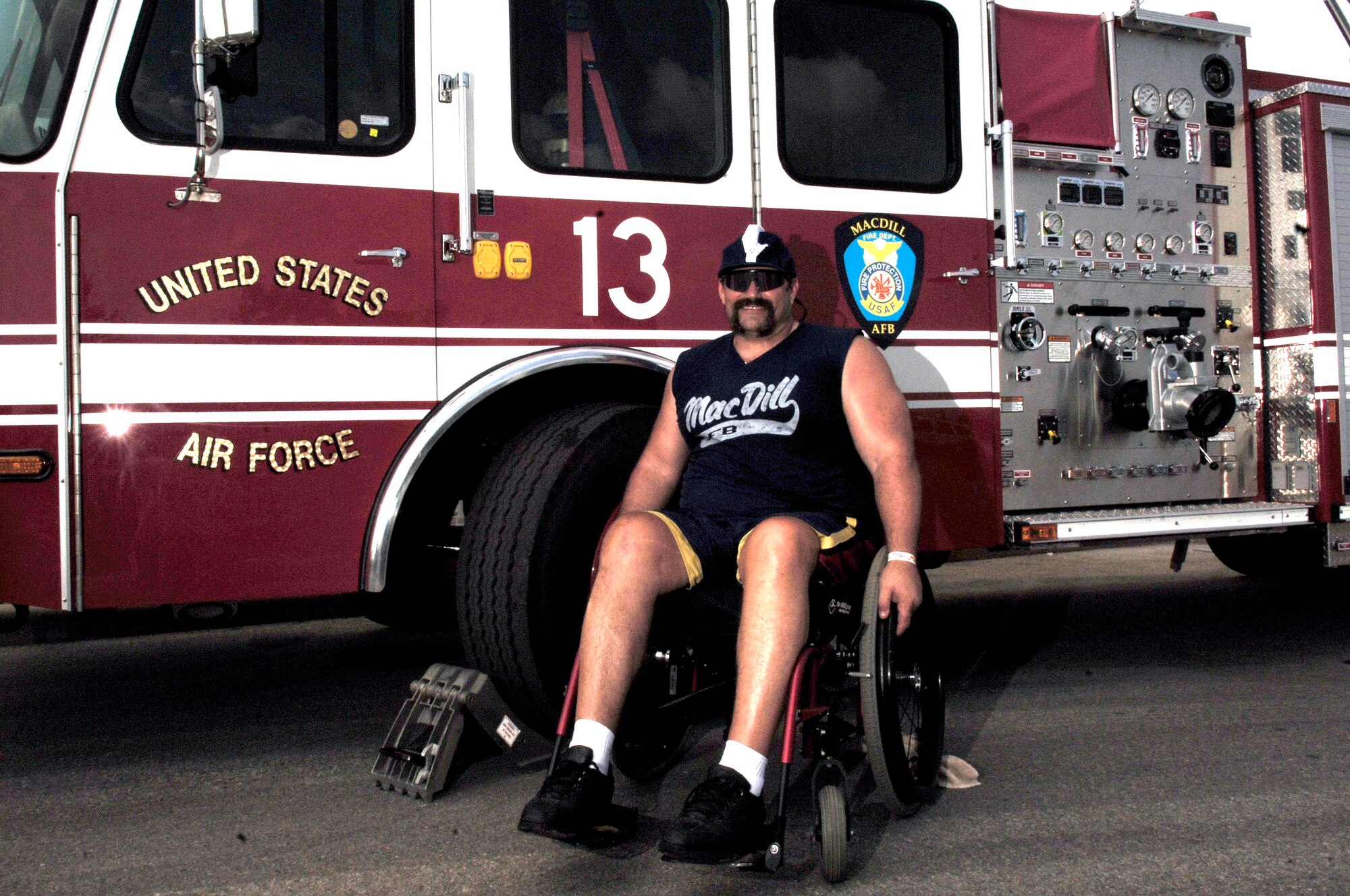 Andy Bernt, 6th Civil Engineer Squadron ( retired) firefighter sits next to a MacDill firetruck the softball tournament May 24. The tournament was held by the MacDill Firefighter's Association to help raise funds toward paying for his cancer treatment.       (U.S. Air Force photo by Senior Airman Bradley Lail)