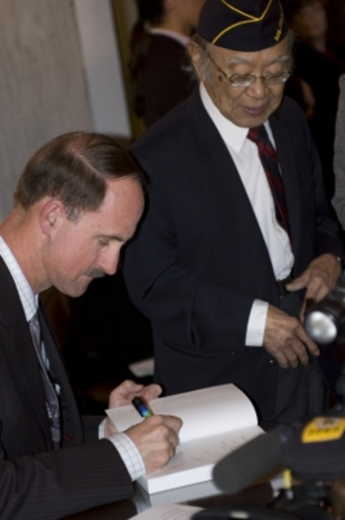Dr. James C. McNaughton autographs his book, "Nisei Linguists: Japanese Americans in the Military Intelligence Service During WWII" for a veteran during a March 20, 2007 Capitol Hill event celebrating the release of the book and paying tribute to the Nisei linguists. The book is published by the U. S. Army Center for Military History.  Dr. McNaughton spoke during a noontime WWII seminar on June 5th at RAF Molesworth UK  (Photo courtesy of U.S. Army Center for Military History)