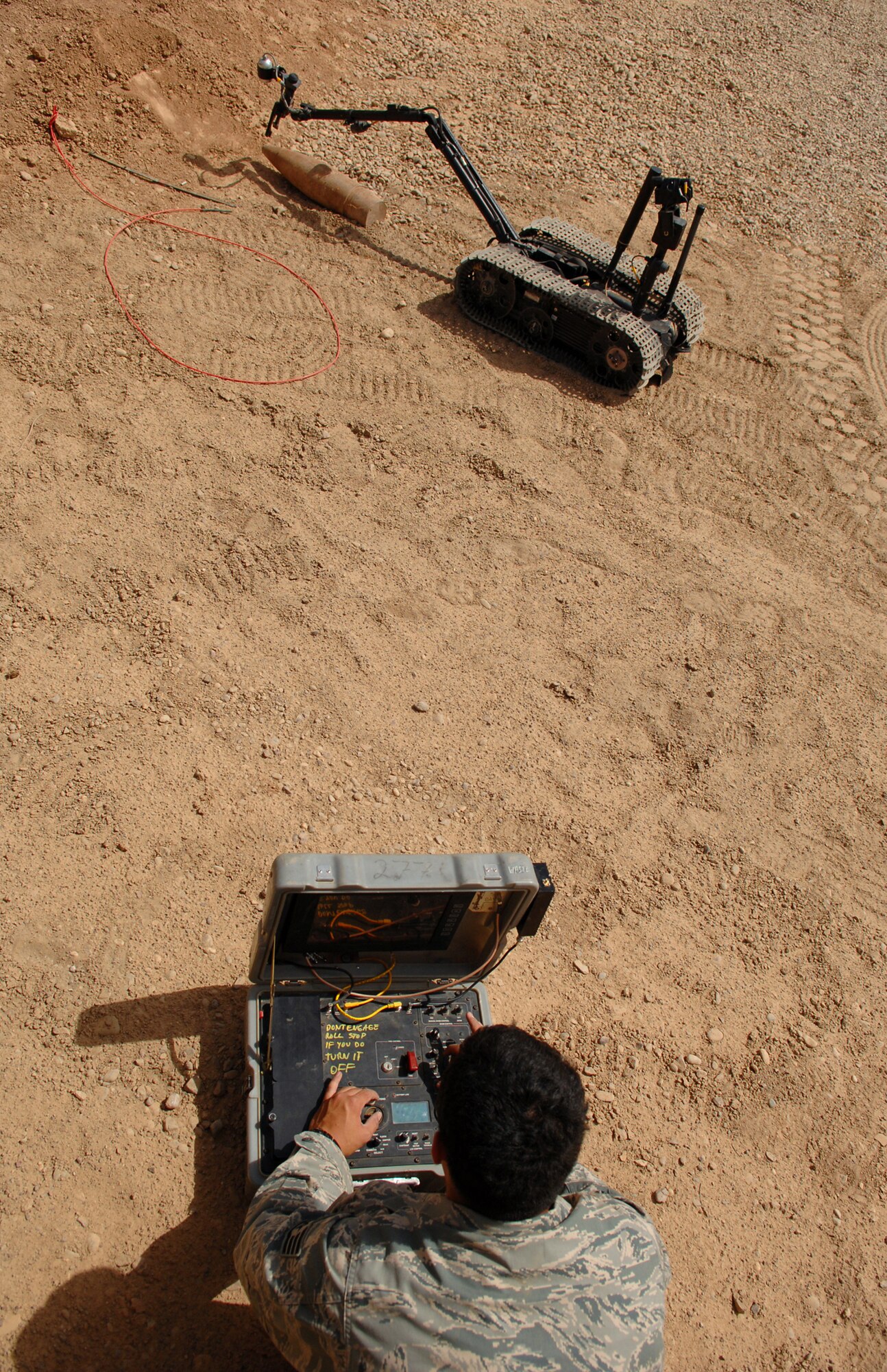 BALAD AIR BASE, Iraq -- Staff Sgt. Christopher Ferrell, 332nd Expeditionary Civil Engineer Squadron explosive ordnance disposal flight noncommissioned officer, tests the operability of the Talon robot by manipulating a disarmed unexploded ordnance here, May 26. The Talon robot saves lives by deactivating the improvised explosive devices and allowing EOD personnel to disarm ordnances from a safe distance rather than disarming them manually. EOD Airmen respond to UXO findings within the confines of Balad AB and also participate in convoy operations with U.S. Army Soldiers identifying and disabling roadside improvised explosive devices that endanger the lives of traveling coalition forces and Iraqi civilians. Robot operators must work quickly and carefully without letting stress affect their performance. Sergeant Ferrell is deployed from Charleston Air Force Base, S.C. (U.S. Air Force photo/ Senior Airman Julianne Showalter) 
