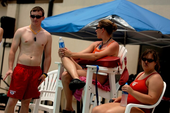 Rick Hallets, Allison Clayton and Vienna Fast observe activities during a recreational swimming session at the base pool May 24. Hallets, Clayton and Fast are lifeguards at the base pool. (U.S. Air Force photo/Senior Airman Nicholas Pilch)
