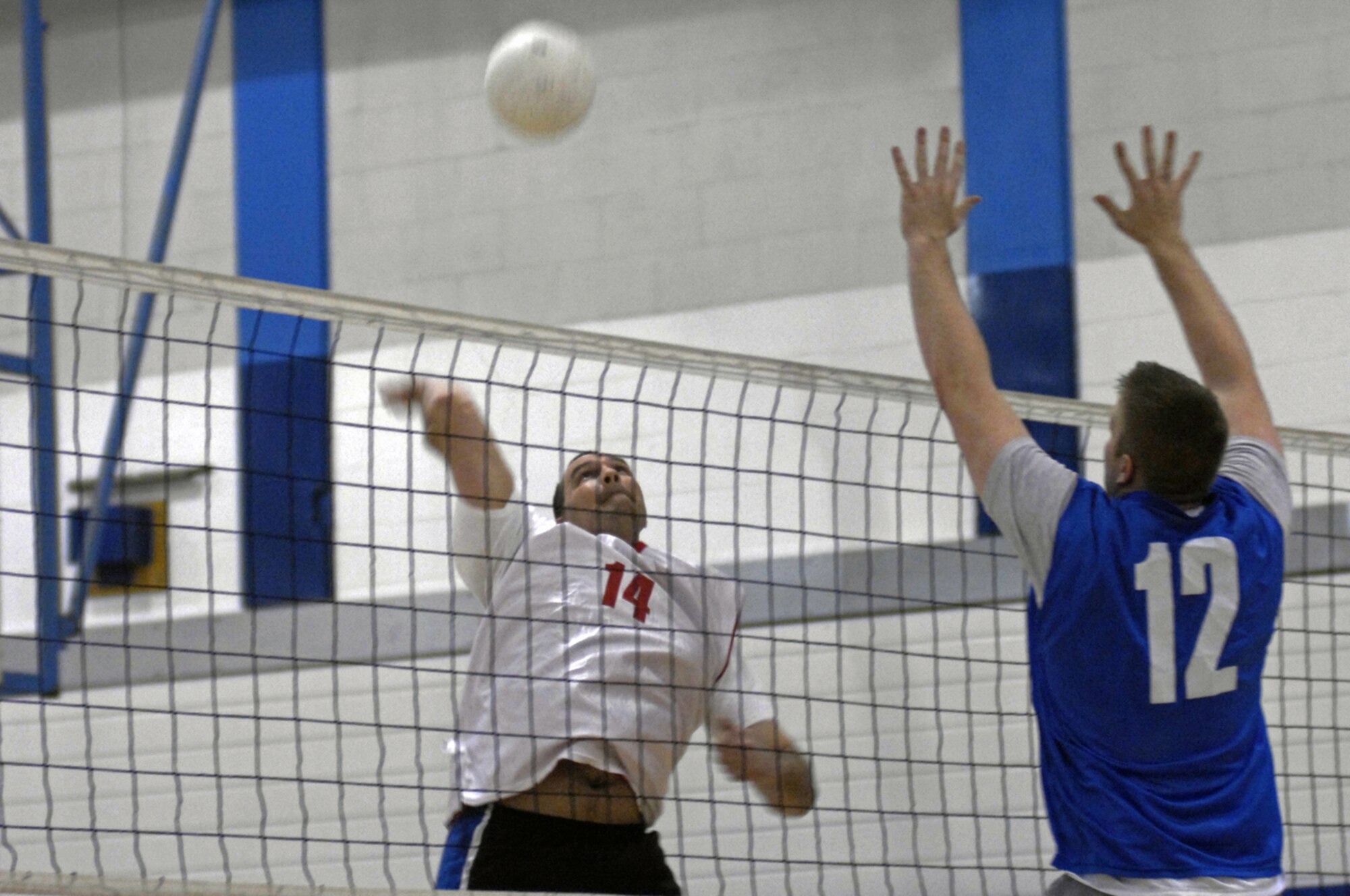 Airman 1st Class Matthew Long, 48th Comptroller Squadron, attempts to block a spike from Tech. Sgt. Mark Willcutt, 48th Equipment Maintenance Squadron, May 21 at RAF Lakenheath, England. The two squadrons played in a double-elimination playoff tournament with CPTS advancing in the winners' bracket and EMS trying to stay alive in the losers' bracket with one loss. (U.S. Air Force photo by Airman Perry Aston)