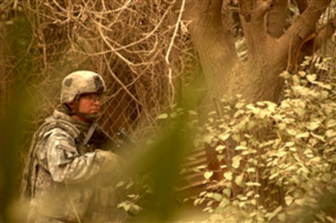A U.S. Army soldier takes cover following a mortar attack during a search for weapons caches in Northwest Shulla, Iraq, on May 16, 2008.  The soldier is assigned to Bravo Troop, 1st Squadron, 75th Cavalry Regiment, 2nd Brigade Combat Team, 101st Airborne Division.  