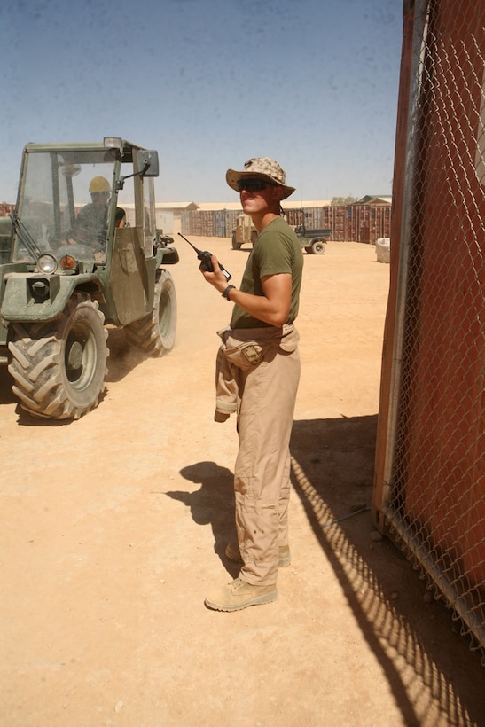 During a daily re-supply operation, Lance Cpl. Joseph M. McDonough, 25, a warehouse clerk with Headquarters and Service Battalion, 2nd Light Armored Reconnaissance Battalion, Regimental Combat Team 5, directs the placement of a shipment at Camp Korean Village, Iraq, May 29. Each day is full of hard work and express delivering for the supply Marines with 2nd LAR, but they depend upon each other for support.