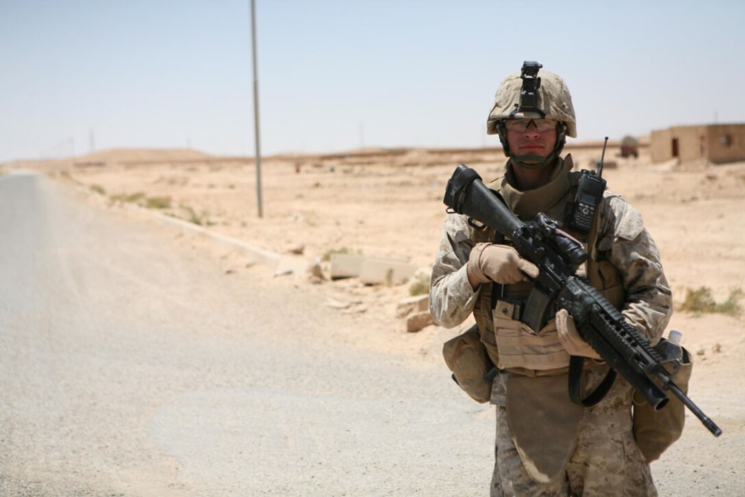 Lance Cpl. Salvador A. Renderos, 20, a radio operator with Headquarters and Services Company, 3rd Battalion, 4th Marine Regiment, Regimental Combat Team 5, from Los Angeles, patrols through the city of Haditha, Iraq, June 2. Marines with Headquarters and Services Co. patrolled to the Haditha City Council to observe the meeting. Along the way, the Marines stopped at a city councilman's home to eat breakfast.
