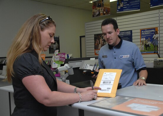 April King signs for a package at the Holloman Air Force Base Post Office May 27. The Post Office is responsible for delivering mail and providing customer service to everyone on base.(U.S. Air Force photo/Senior Airman Tiffany Trojca)