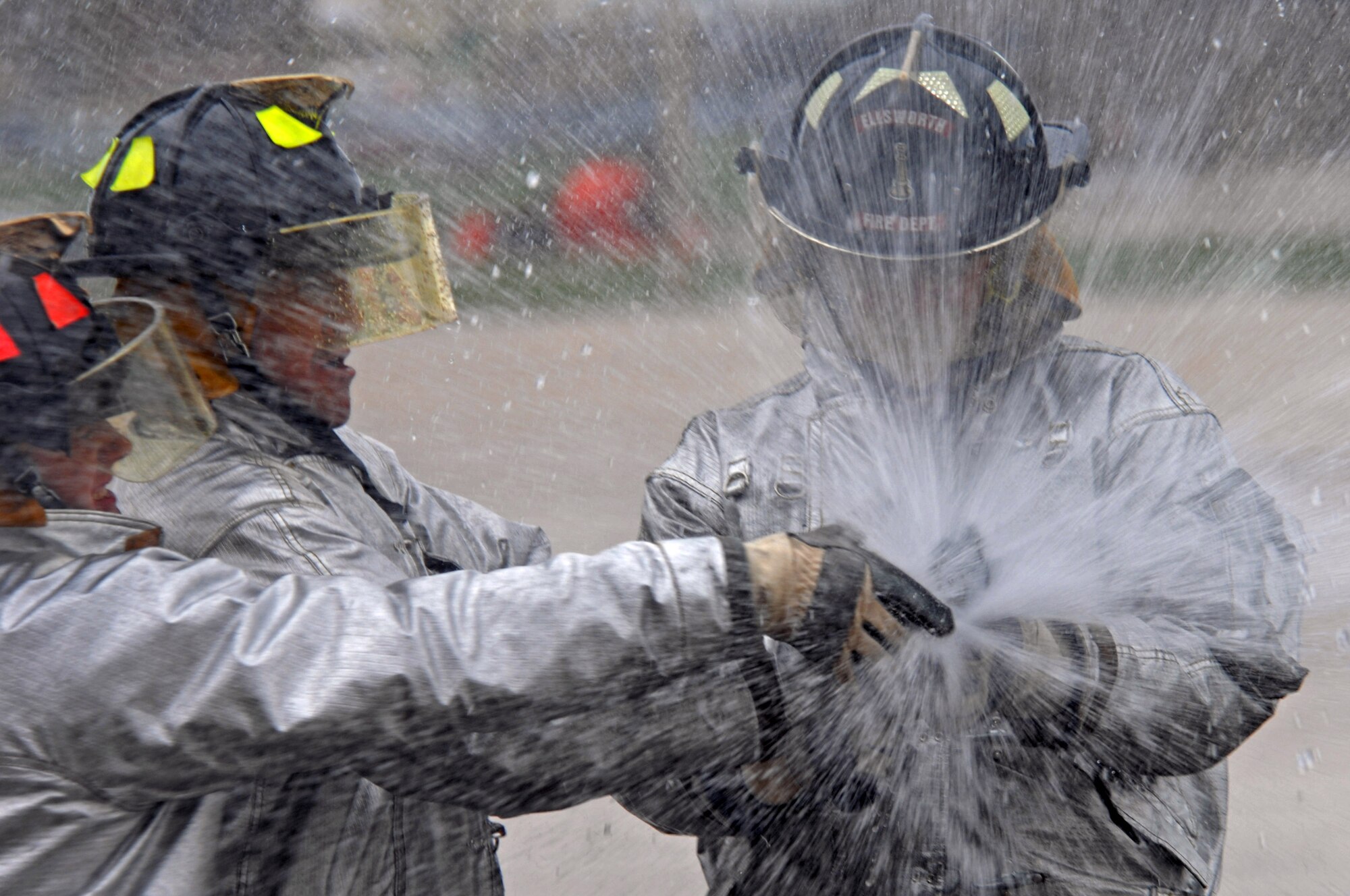Members of Ellsworth adjust a fire hose during the water barrel spraying contest in the Firefighter Challenge here, May 28. The challenge was open to all Airmen and members of the Ellsworth community. (U.S. Air Force photo/Airman Corey Hook) 