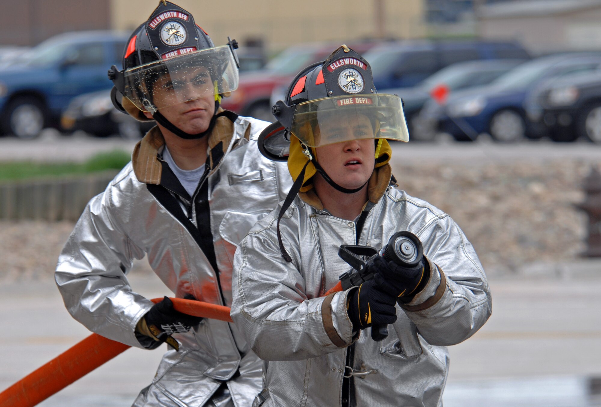 (Front) Airmen 1st Class Christopher Carrell and John Vasquez, 28th Civil Engineer Squadron firefighters, prepare to begin the final round of the Ellsworth Firefighter Challenge here, May 28. A member from each team competed against each other to see who could charge the hose the quickest in order to provide water to spray the barrels. (U.S. Air Force photo/Airman Corey Hook)