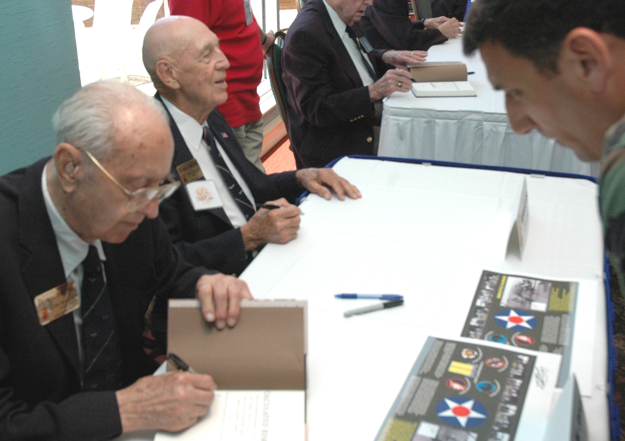 Doolittle Raiders Maj. Gen. Davey Jones (left) and Lt. Col. Dick Cole sign autographs at Eglin's Officer's Club May 28. 