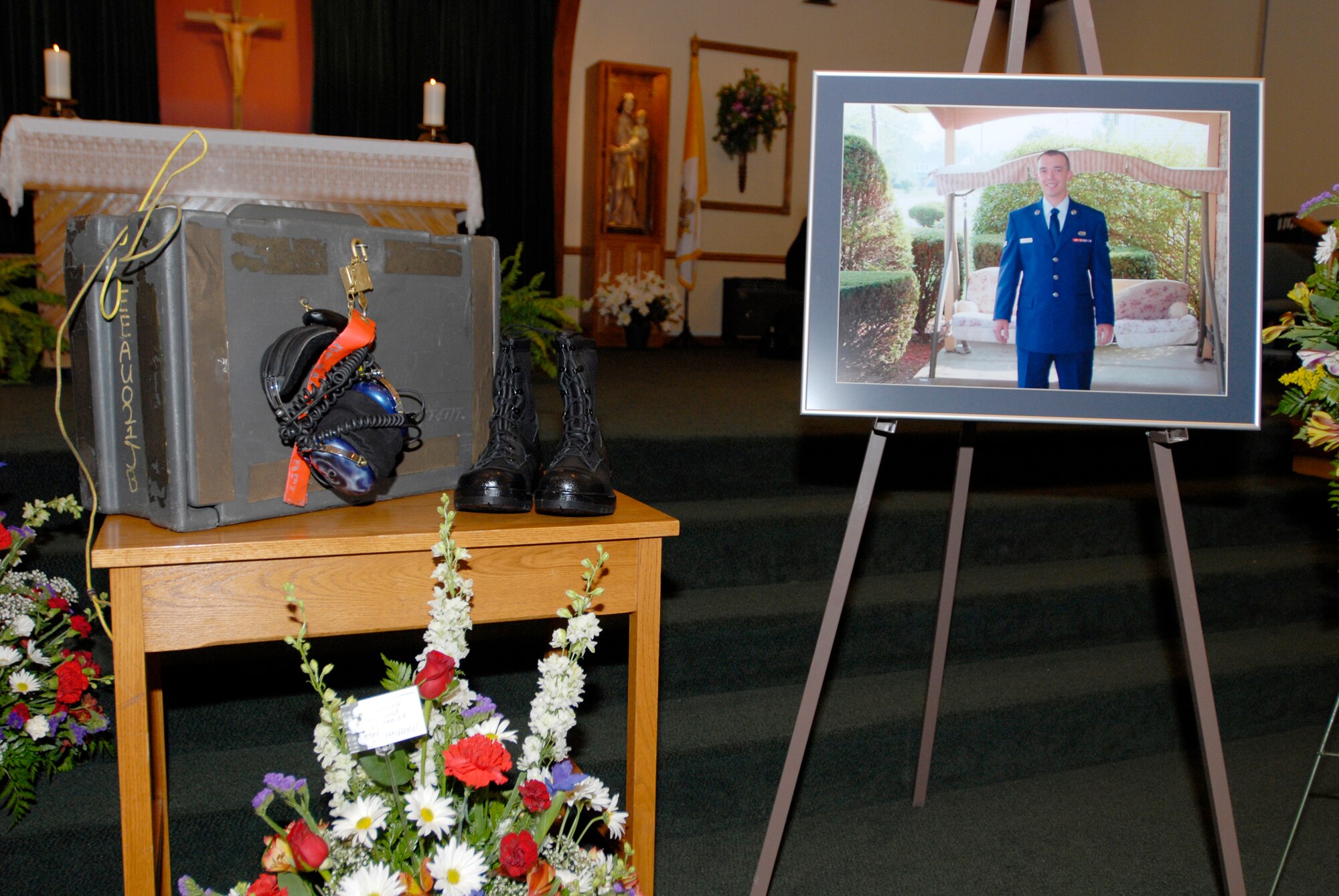 Flowers, boots, tools and a photograph stand together in the Hurlburt Field Chapel May 30 during the memorial service for Airman 1st Class Eric Toothaker, 1st Special Operations Aircraft Maintenance Squadron. Family, friends and coworkers filled the chapel to standing-room only to honor Airman Toothaker, who died May 27 in a kayaking incident. (U.S. Air Force photo/Airman 1st Class Jason Epley)