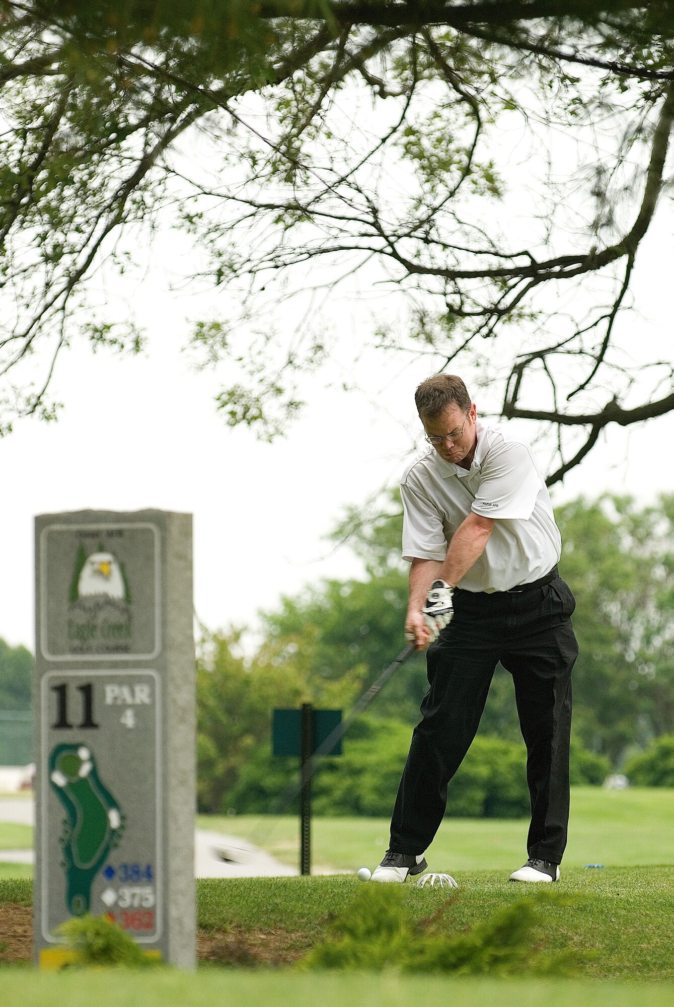 Tech. Sgt. Larry Pfeil, 9th Airlift Squadron, tees off from the 11th green during intramural golf May 27 at the Eagle Creek Golf Course. Sergeant Pfeil played with fellow squadron members Tech. Sgt. Steve Dirksen and Staff Sgt. John Crump. (U.S. Air Force photo/Roland Balik)