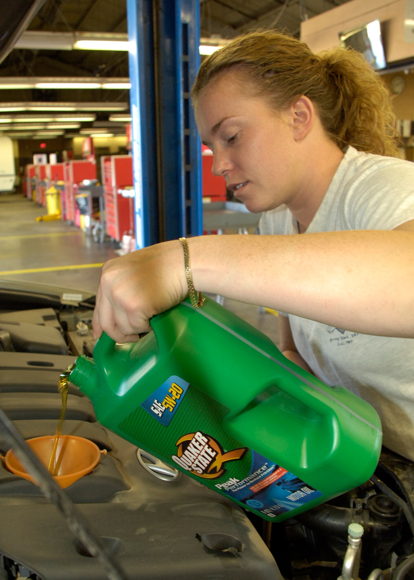 Airman 1st Class Krista Lawrence, 49th Civil Engineer Squadron, changes the oil in her vehicle at the Auto Hobby Center on Holloman Air Force Base, N.M., May 22. The center offers one on one teaching assistance for any task you wish to tackle. (U.S. Air Force photo/Airman 1st Class Michael Means)