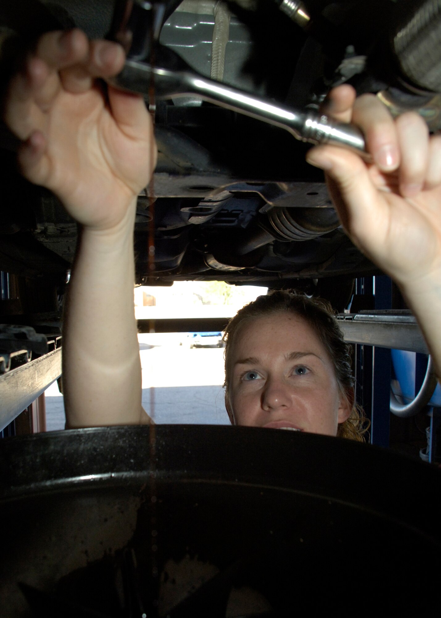 Airman 1st Class Krista Lawrence, 49th Civil Engineer Squadron, drains the oil in her vehicle at the Auto Hobby Center on Holloman Air Force Base, N.M., May 22. The Auto Hobby Center offers tool and equipment for your use. (U.S. Air Force photo/Airman 1st Class Michael Means)