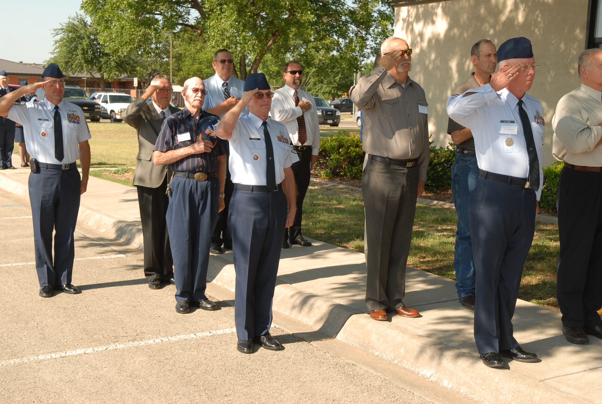 Former commandants of the Goodfellow NCO Academy and other chief master sergeants salute the American Flag during the academy’s final retreat May 28. (U.S. Air Force photo by Staff Sgt. John Barton)
