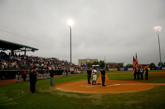 Senior Airmen Kris Butler and Sam Hymas sing the National Anthem while Marine Sgt. George Jordan, Gunnery Sgt. Michael Curby, Sgt. Ray Soto and Cpl. David Sports present the flag to open the Charleston Riverdogs game at Joseph P. Riley Jr. Park in Charleston, S.C., May 29. The Riverdogs and Force Protection Industries Inc. organizations donated free tickets to thousands of base Airmen and family members to attend the game as a small token of appreciation for their service. Airman Butler is with the 437th Aircraft Maintenance Squadron, Airman Hymas is with the 437th Airlift Wing and Sergeants Jordan, Curby, Soto and Corporal Sports are from the 4th Charlie Company Land Support Battalion, Charleston, S.C.  (U.S. Air Force photo/Senior Airman Nicholas Pilch)