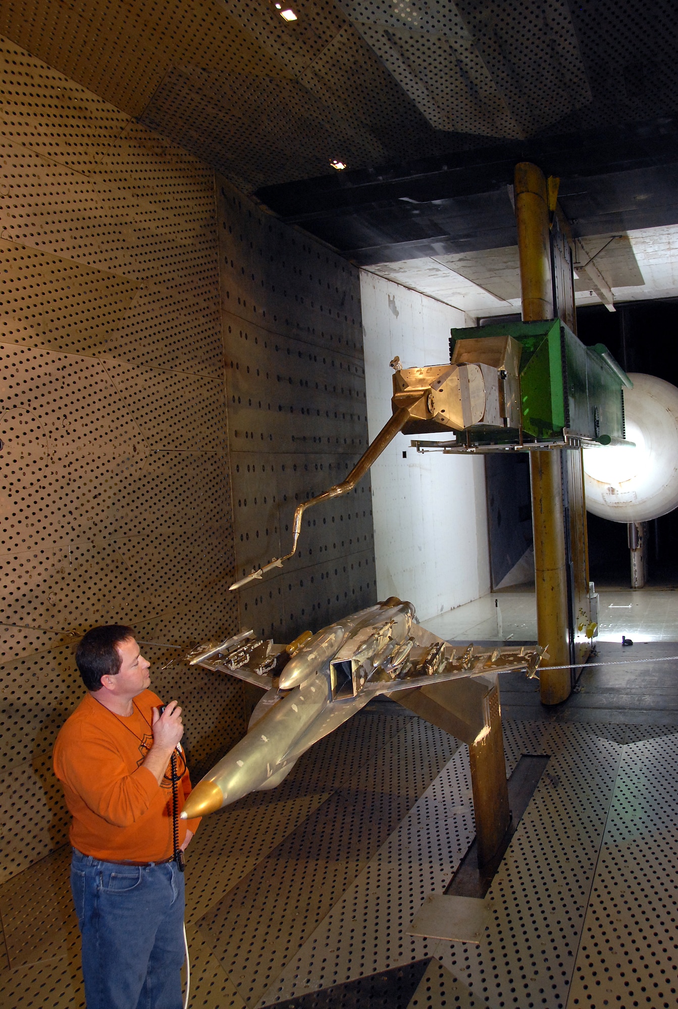 Tim Wright, an Aerospace Testing Alliance outside machinist, coordinates the movement of a 1/10-scale model, sting-mounted AIM-120C store from an F/A-18E/F aircraft during a break in store separation testing inside AEDC’s 16-foot transonic wind tunnel. ATA is the support contractor for the center. (Photo by David Housch)