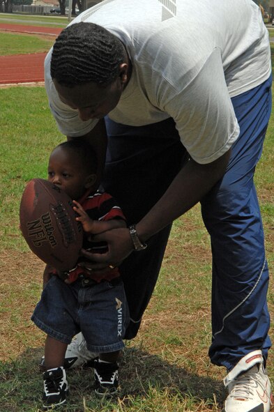 BARKSDALE AIR FORCE BASE, La. - Airman 1st Class JaMichael Jackson plays football with his son JaMichael Jackson Jr. during a wing sports day held at the fitness center here on May 22. (U.S. Air Force photo by Airman 1st Class Joanna M. Kresge) 