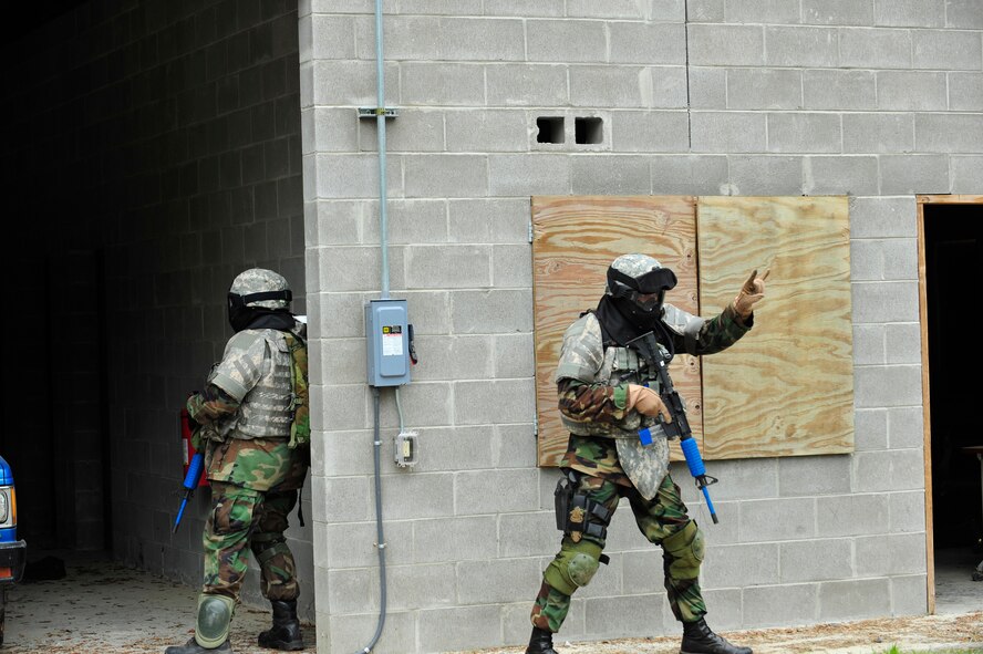MOODY AIR FORCE BASE, Ga -- Capt. Ian Dinesen, 820th Security Forces Group operations officer, communicates to his team that two enemy prisoners of war have been identified in a building during combat medical skills training here May 22.  The realistic training prepares the 820th SFG for futue deployments. (U.S. Air Force photo by Senior Airman Schelli Jones) 
