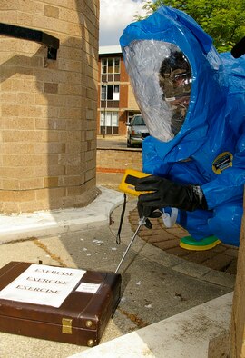 Airman 1st Class David Norris, 100th CES Readiness and Emergency Management, uses a detector to check for radiological, biological and chemical agents on and around the supsicious package during an exercise May 23. (U.S. Air Force photo by Karen Abeyasekere)
