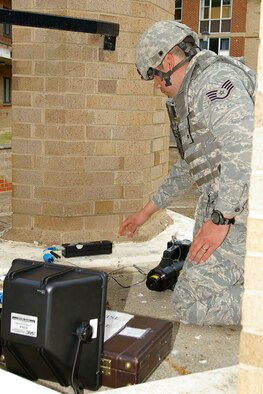 Staff Sgt. Alex Rodriguez, 48th Civil Engineer Squadron Explosive Ordnance Disposal sets up X ray equipment near the "suspicious package" during an exercise May 23. (U.S. Air Force photo by Karen Abeyasekere)