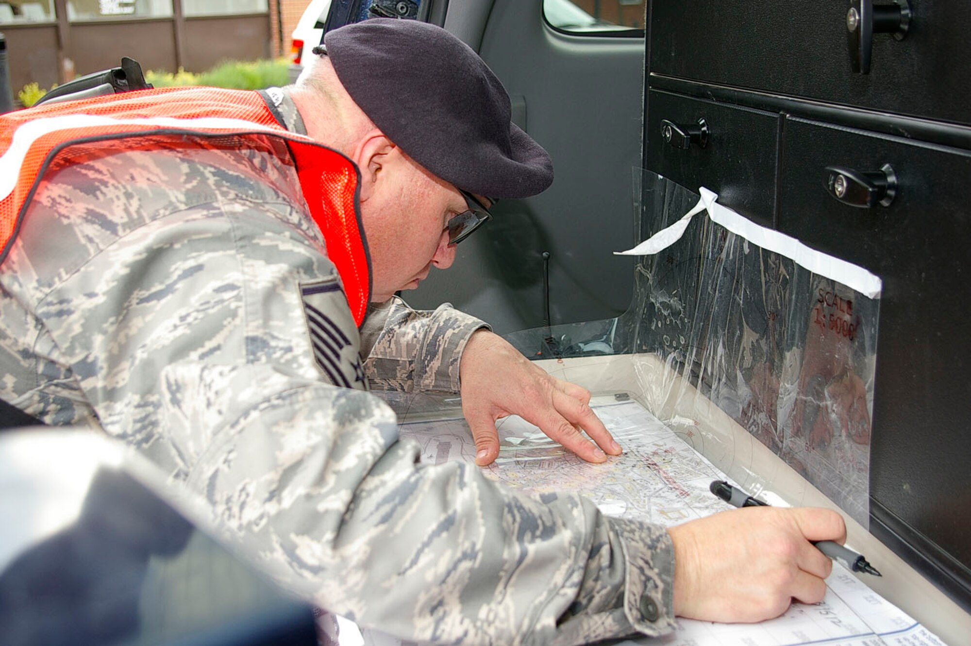Master Sgt. William Pacheco, 100th Security Forces Squadron, plots a cordon on a base map to ensure buildings are (simulated) evacuated during an exercise May 23. Once the cordon it plotted, the infomation can then be upchannelled to ensure everyone is out of the danger area. (U.S. Air Force photo by Karen Abeyasekere)