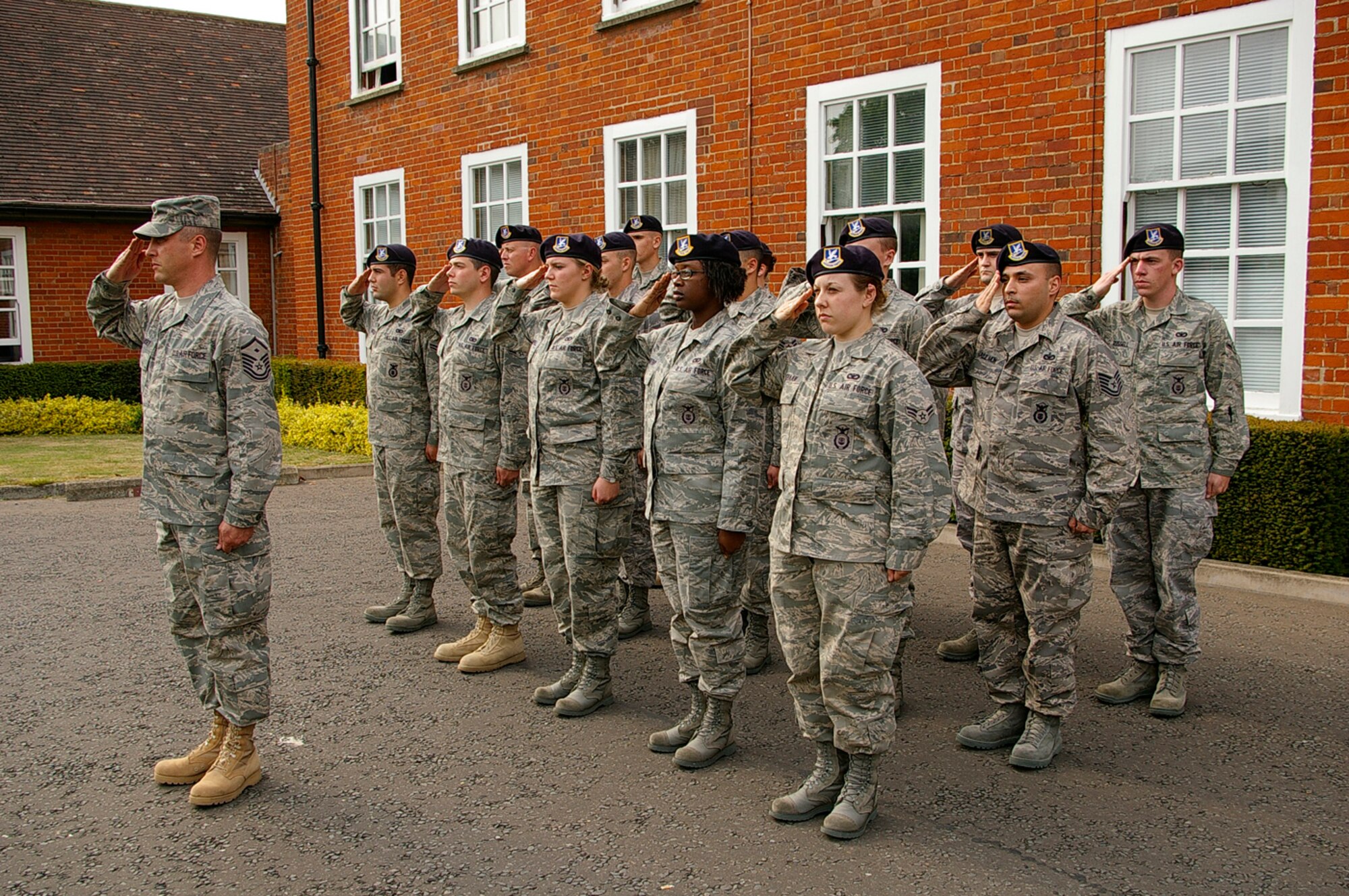 Master Sgt. Todd Ramsey, left, 100th Security Forces Squadron first sergeant and other 100th SFS Airmen salute the flags during a Police Week retreat May 15. (U.S. Air Force photo by Karen Abeyasekere)