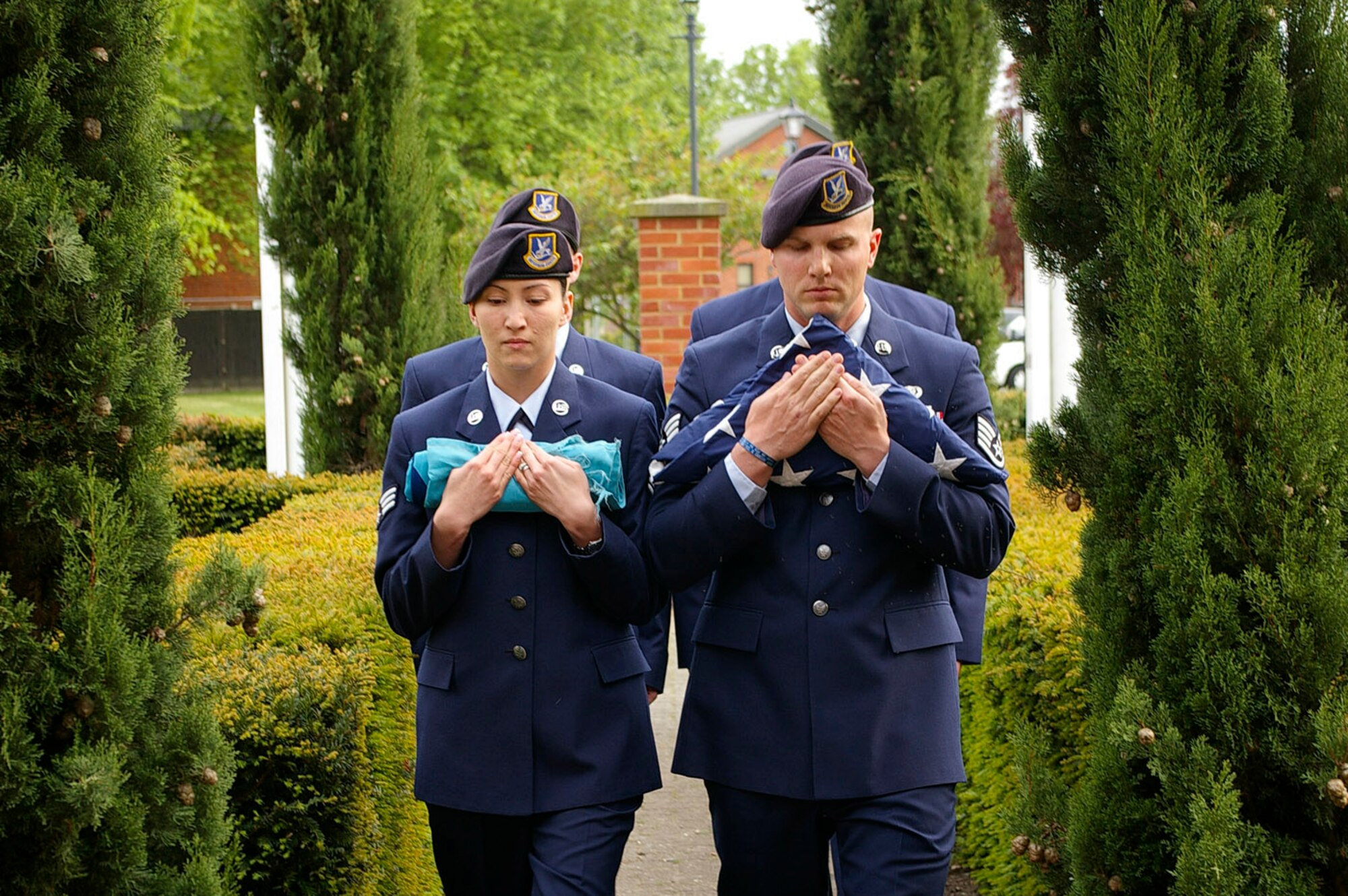 Members from the 100th Security Forces Squadron Color Guard walk solelmnly towards the 100th Air Refueling Wing headquarters building carrying the Royal Air Force and U.S. flags May 15. The 100th SFS gathered at the flagpole and performed the retreat as part of National Police Week events. In the four-person Color Guard team were Senior Alicia Goetschel, front left, Staff Sgt. Clinton Petit, front right, Senior Airman Patrick Kopacko, rear left, and Airman 1st Class James Joyce, rear right. (U.S. Air Force photo by Karen Abeyasekere)