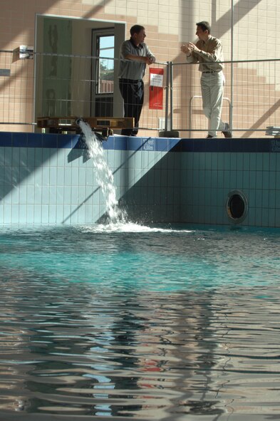 Norman Guenther (left), Air Force Center for Engineering and the Environment project manager, and Frank Mahlau, Züblin project engineer, supervise the first filling of the lap pool within Ramstein's new aquatic center, May 9.  Construction is now 92 percent complete and the opening ceremony is scheduled for July 1st.  Photo by Airman 1st Class Amber Bressler