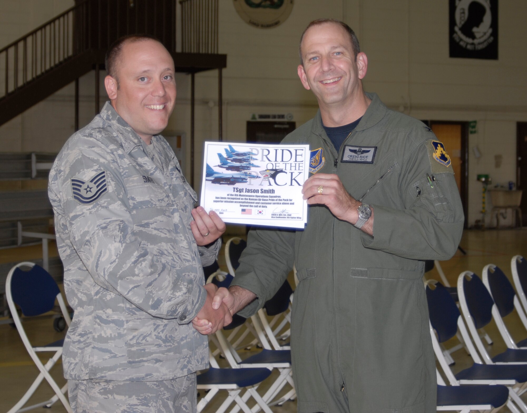 KUNSAN AIR BASE, Republic of Korea -- Colonel Creig "Wolf 2" Rice, 8th Fighter Wing vice commander, congratulates Tech. Sgt. Jason Smith, 8th Maintenance Operations Squadron, here May 30. Sergeant Smith was the 8th Fighter Wing's Pride of the Pack for the week of May 26.  (U.S. Air Force photo/Staff Sgt. Alice Moore) 
