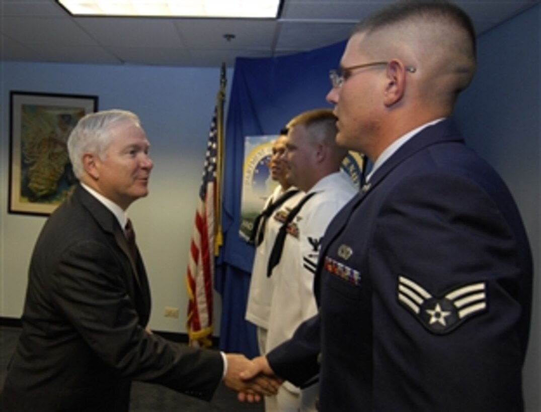 Defense Secretary Robert M. Gates congratulates Air Force Airman 1st Class David Wood and Navy Petty Officers Reynaldo Aurellano and Jonathon Smith after administering the ceremonial oath of re-enlistment to them on Andersen Air Force Base, Guam, May 30, 2008. Gates is on a seven-day trip visiting the Pacific and to attend the 2008 Shangri-La Dialogue in Singapore. 