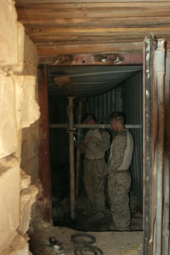 Marines from 4th Combat Engineer Battalion set C-4 explosive charges, preparing to destroy a bunk that was said to have been used to store enemy weapons systems. The Marines destroyed the bunker so that it could not be used against Coalition Forces in the future.