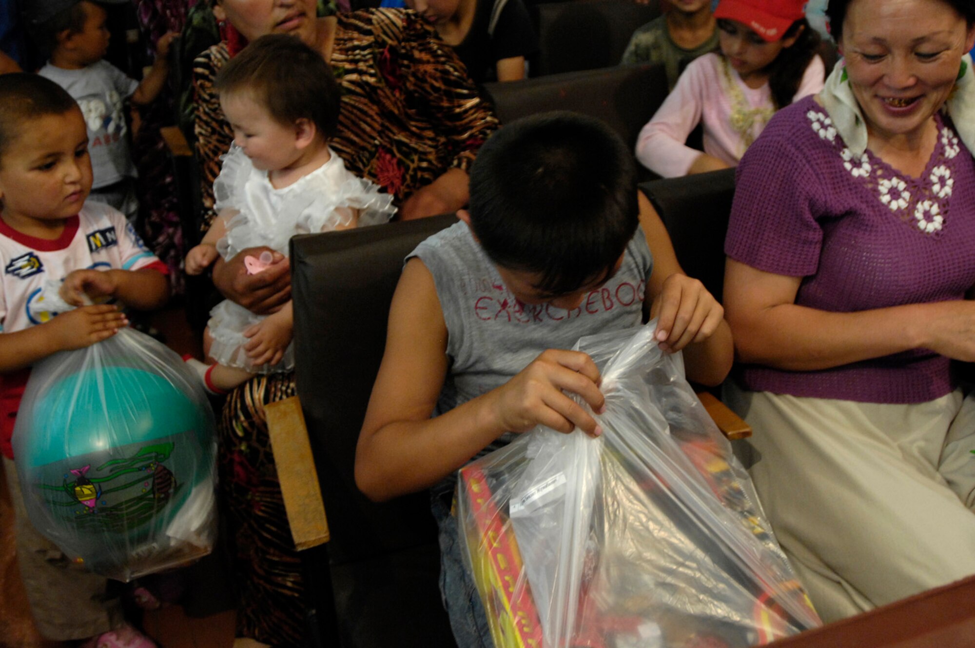 Less fortunate members of Oktyabrskoye village receive gift bags from Airmen of the 376th Expeditionary Security Forces Squadron, Manas Air Base, Kyrgyz Republic, on May 30 as part of the village's recognition of International Protection Day, which is June 1. The Airmen delivered gift bags of hygiene products, T-shirts,  towels, candy, coloring books, toys, and other much needed supplies. The items were purchased with money allocated from the private organizations on base and with donations from home units of the security forces members. (U.S. Air Force Photo by Staff Sgt. Tabitha Kuykendall) (RELEASED) 